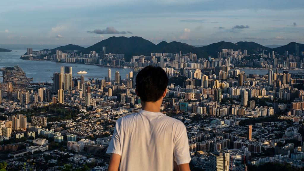 A man views he skyline and buildings from the Beacon Hill in
