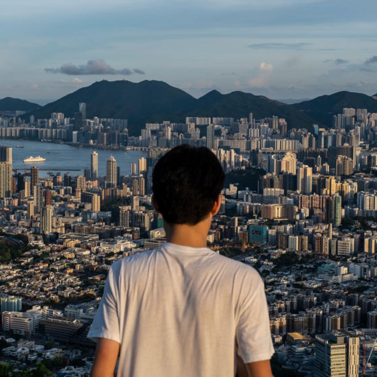 A man views he skyline and buildings from the Beacon Hill in