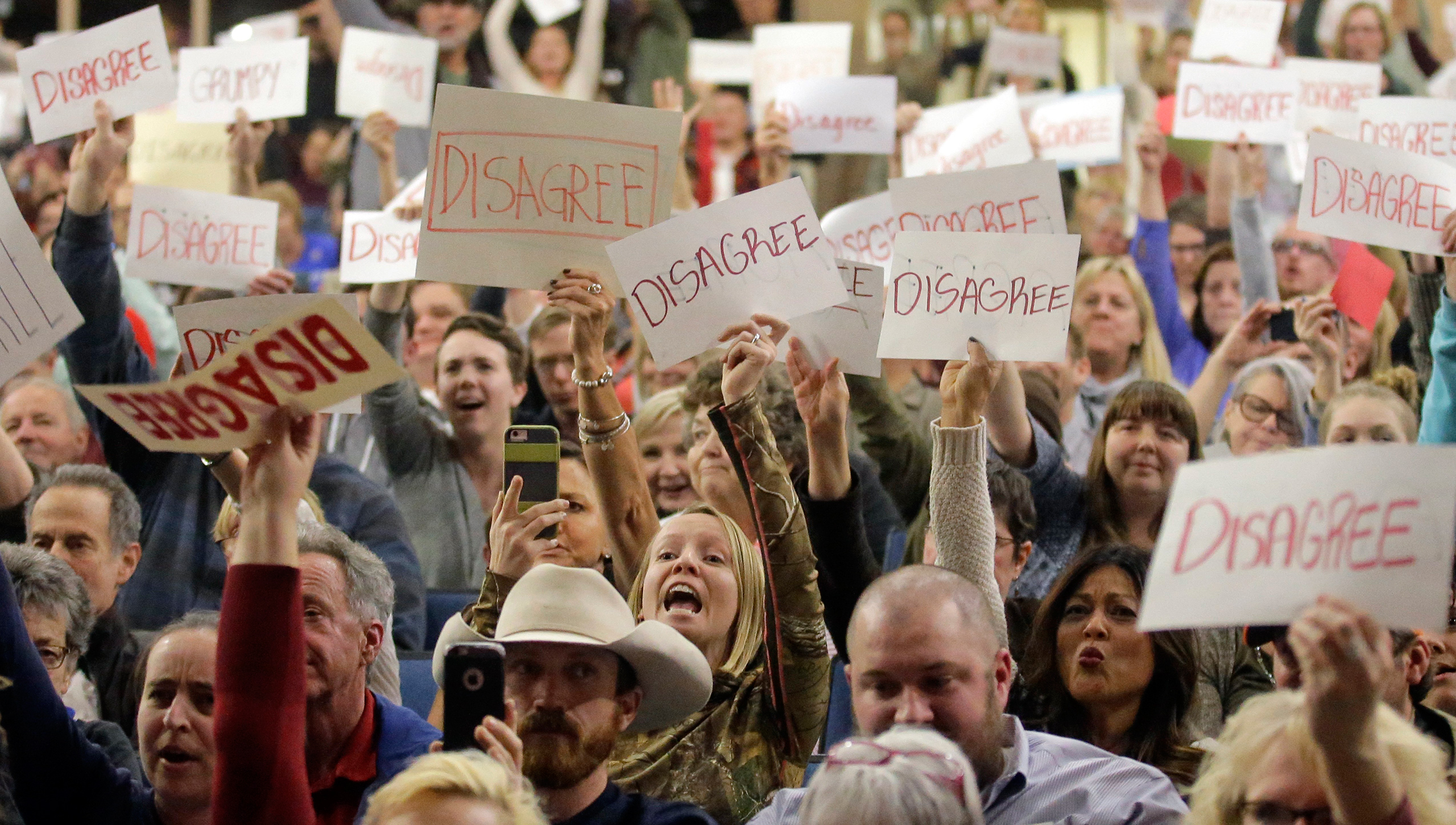 In this Thursday, Feb. 9, 2017 photo, people react as U.S. Rep. Jason Chaffetz speaks during a town hall meeting at Brighton High School in Cottonwood Heights, Utah. Some attendees of the contentious town hall hosted by Chaffetz have sent the congressman fake invoices after he claimed some people there were paid protesters. 