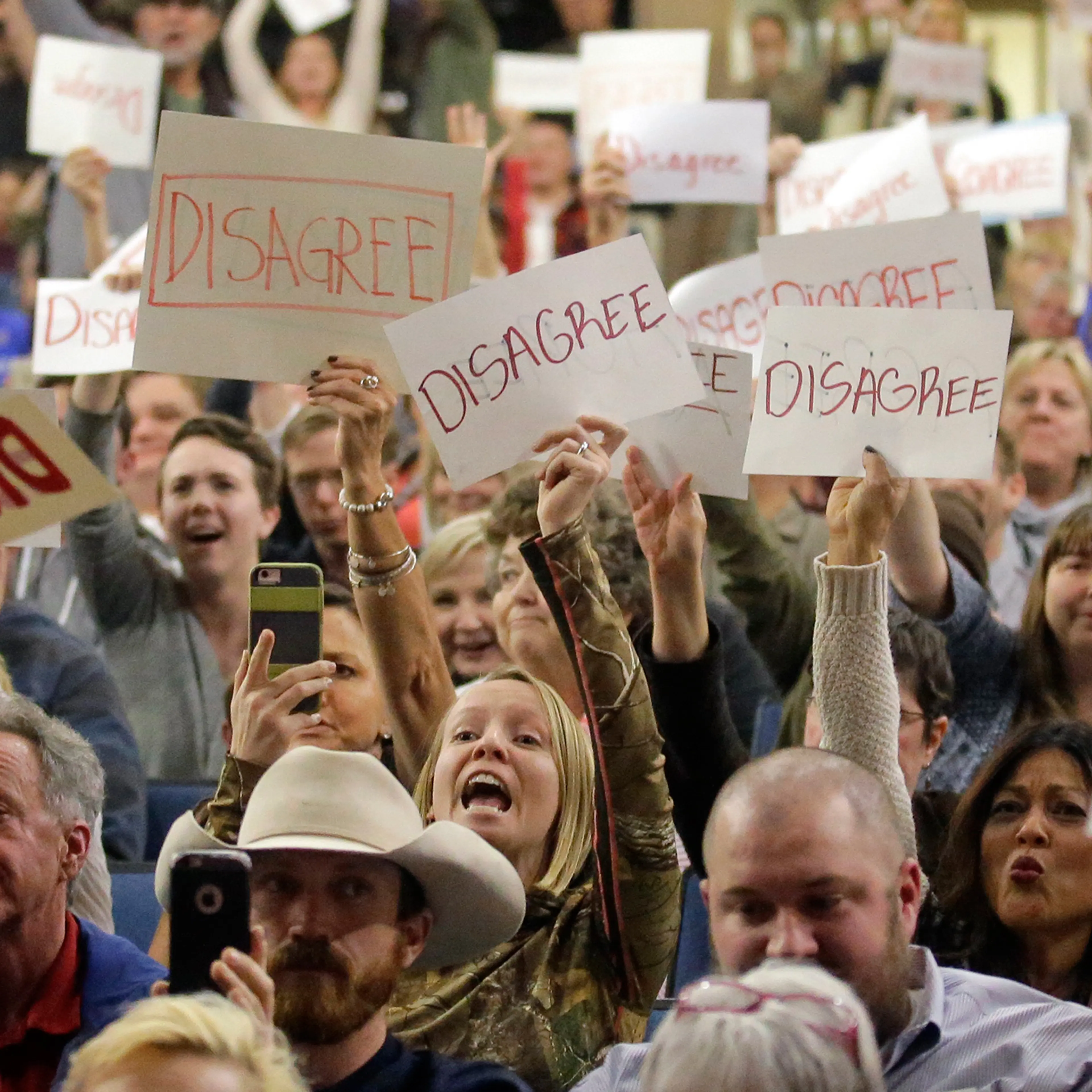 In this Thursday, Feb. 9, 2017 photo, people react as U.S. Rep. Jason Chaffetz speaks during a town hall meeting at Brighton High School in Cottonwood Heights, Utah. Some attendees of the contentious town hall hosted by Chaffetz have sent the congressman fake invoices after he claimed some people there were paid protesters.