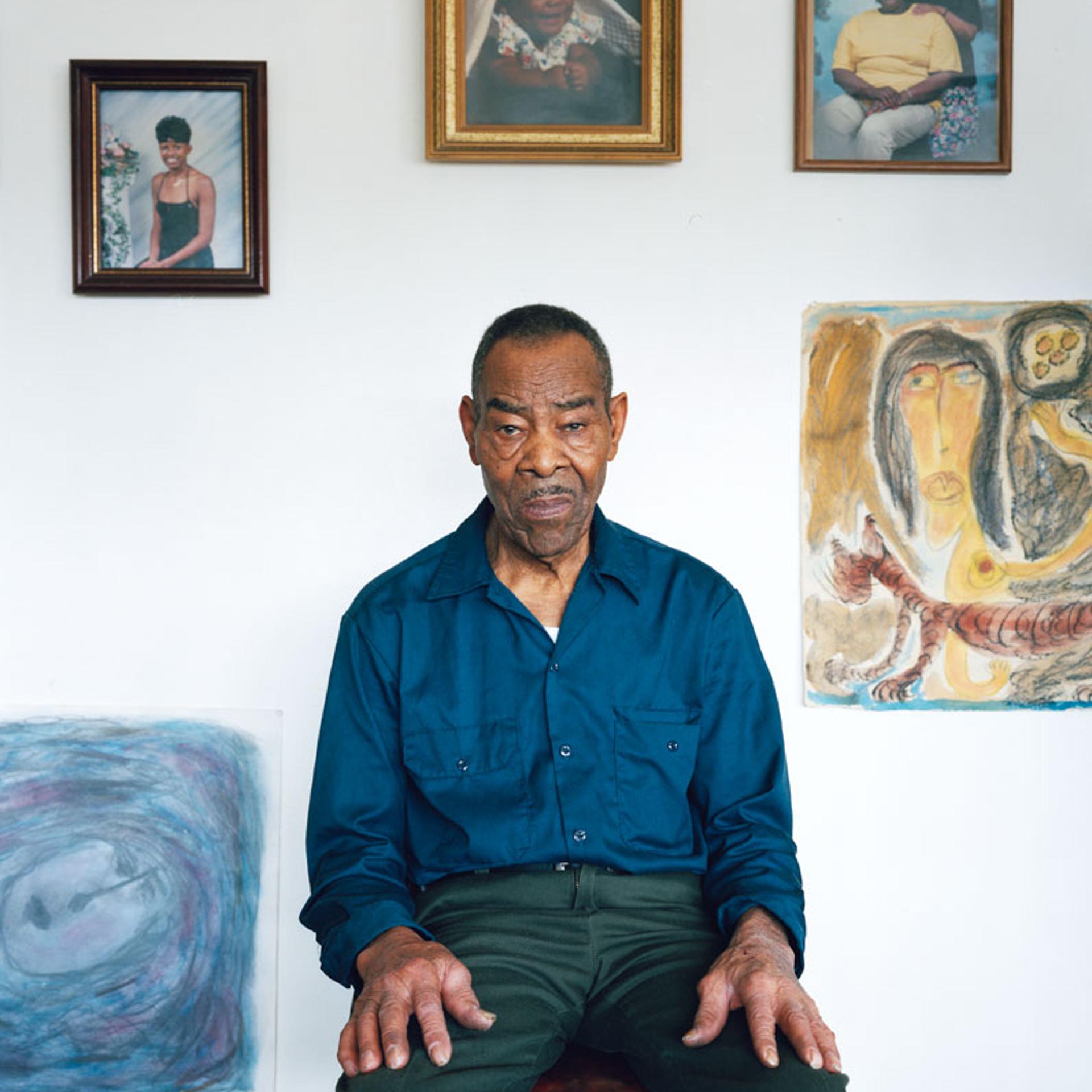 Thornton Dial at his home in Bessemer, Alabama. Surrounded by family photos and his drawings.