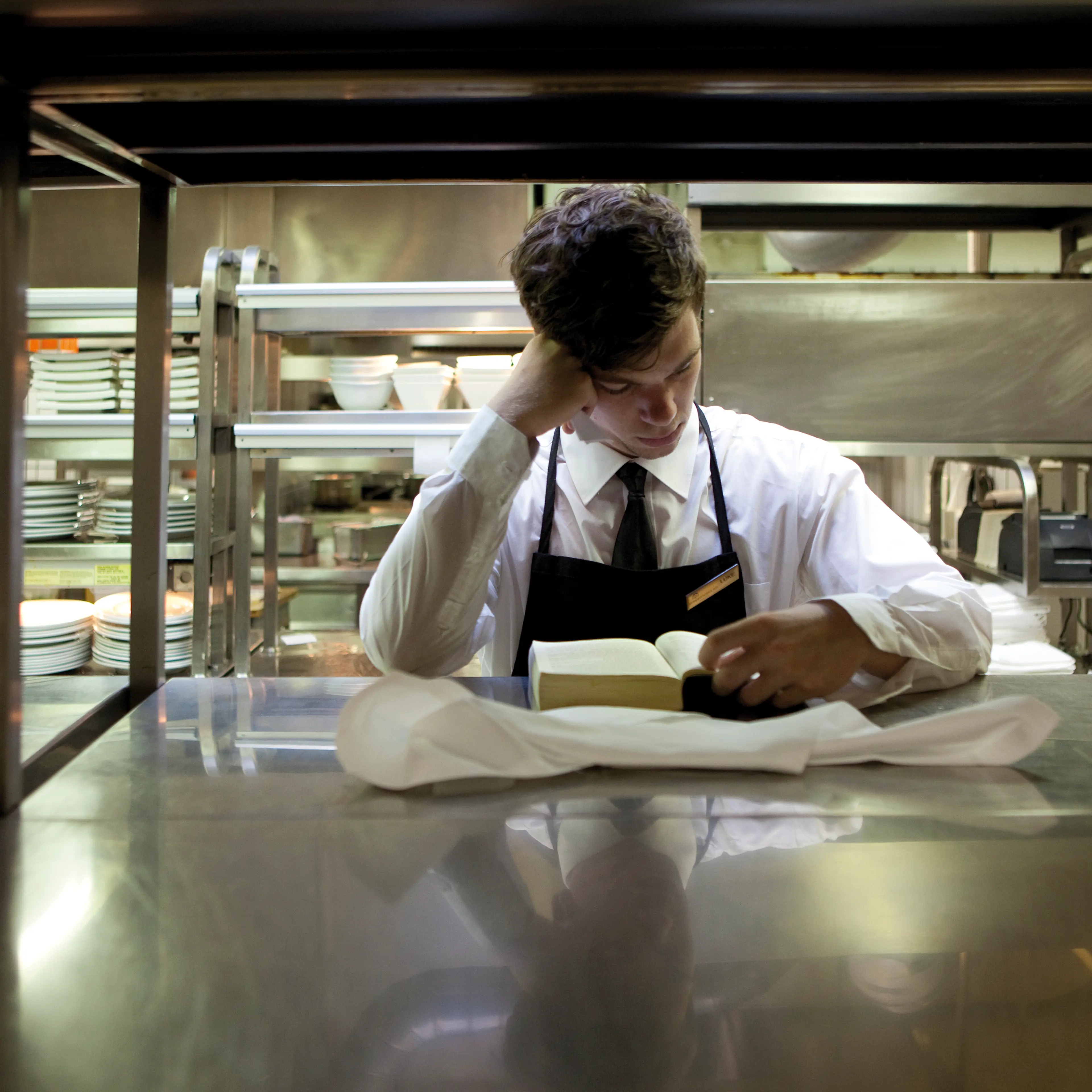 Waiter reading a book