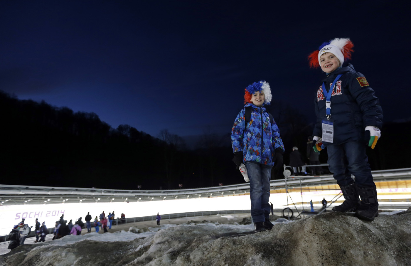 Children wait for the start of the final run during the men's doubles luge at the 2014 Winter Olympics, on Feb. 12, 2014, in Krasnaya Polyana, Russia.