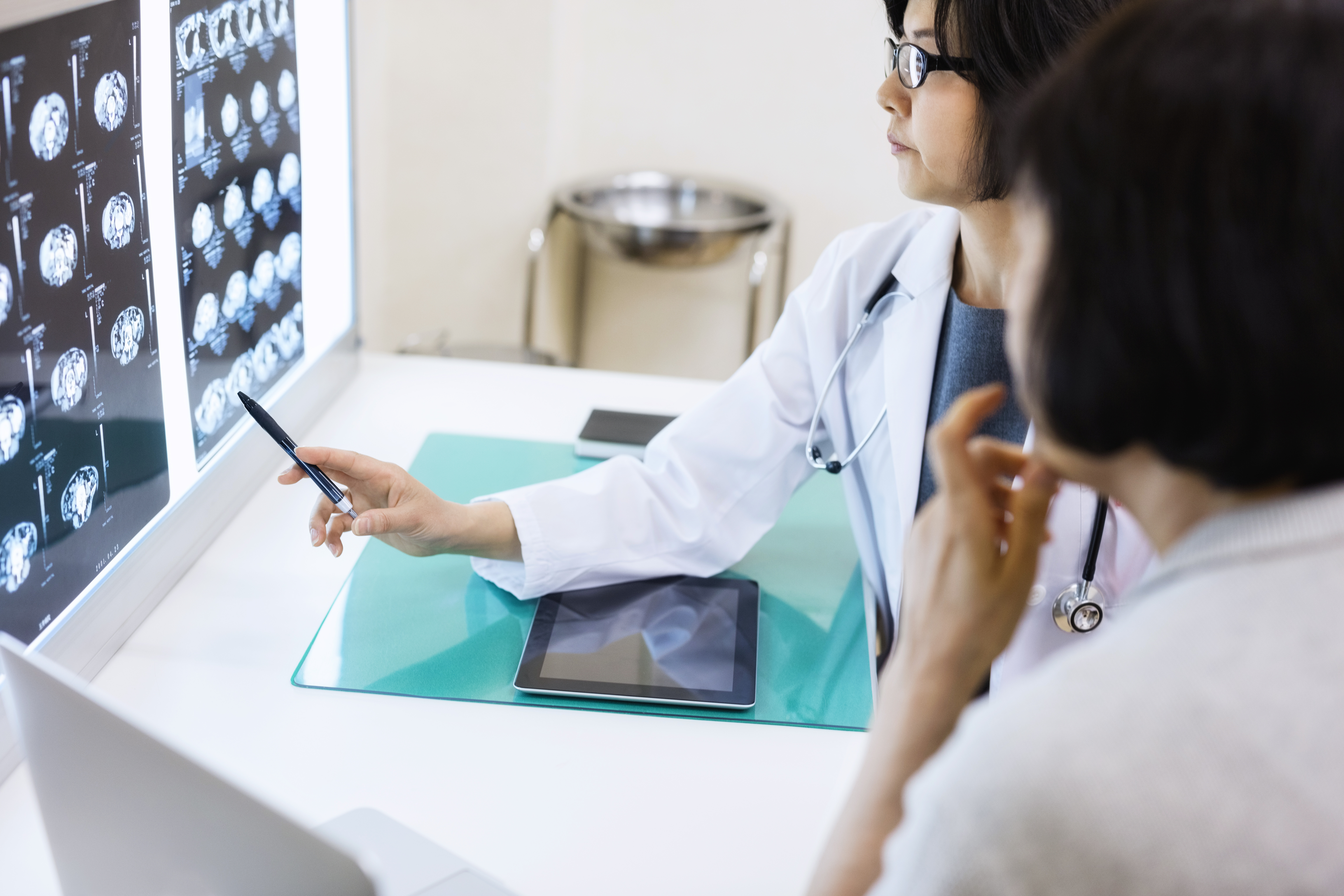 Female doctor discussing with woman over MRIs in hospital