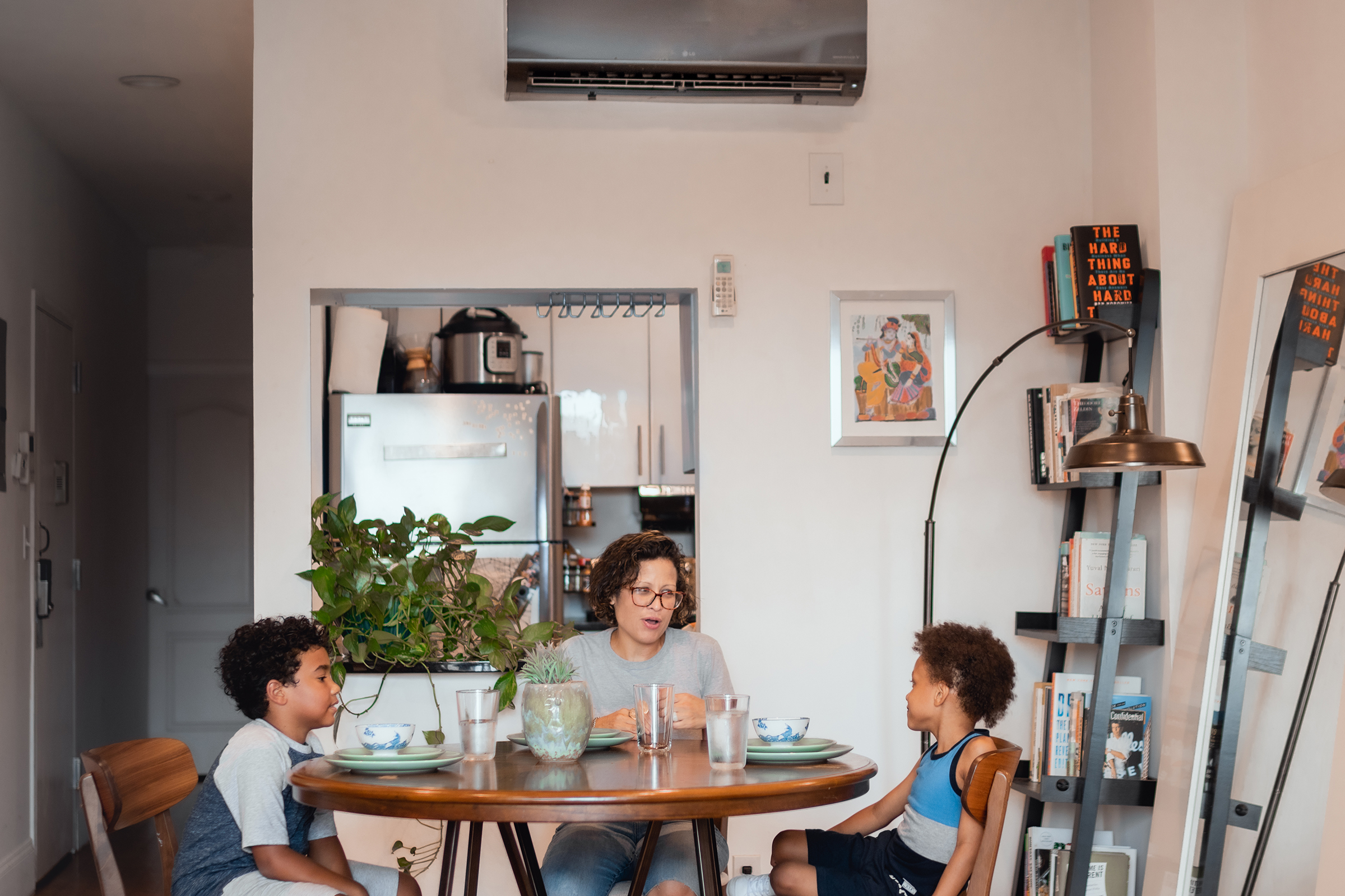 A Family in the Bedford–Stuyvesant neighborhood of Brooklyn eats dinner underneath a BlocPower heating unit.