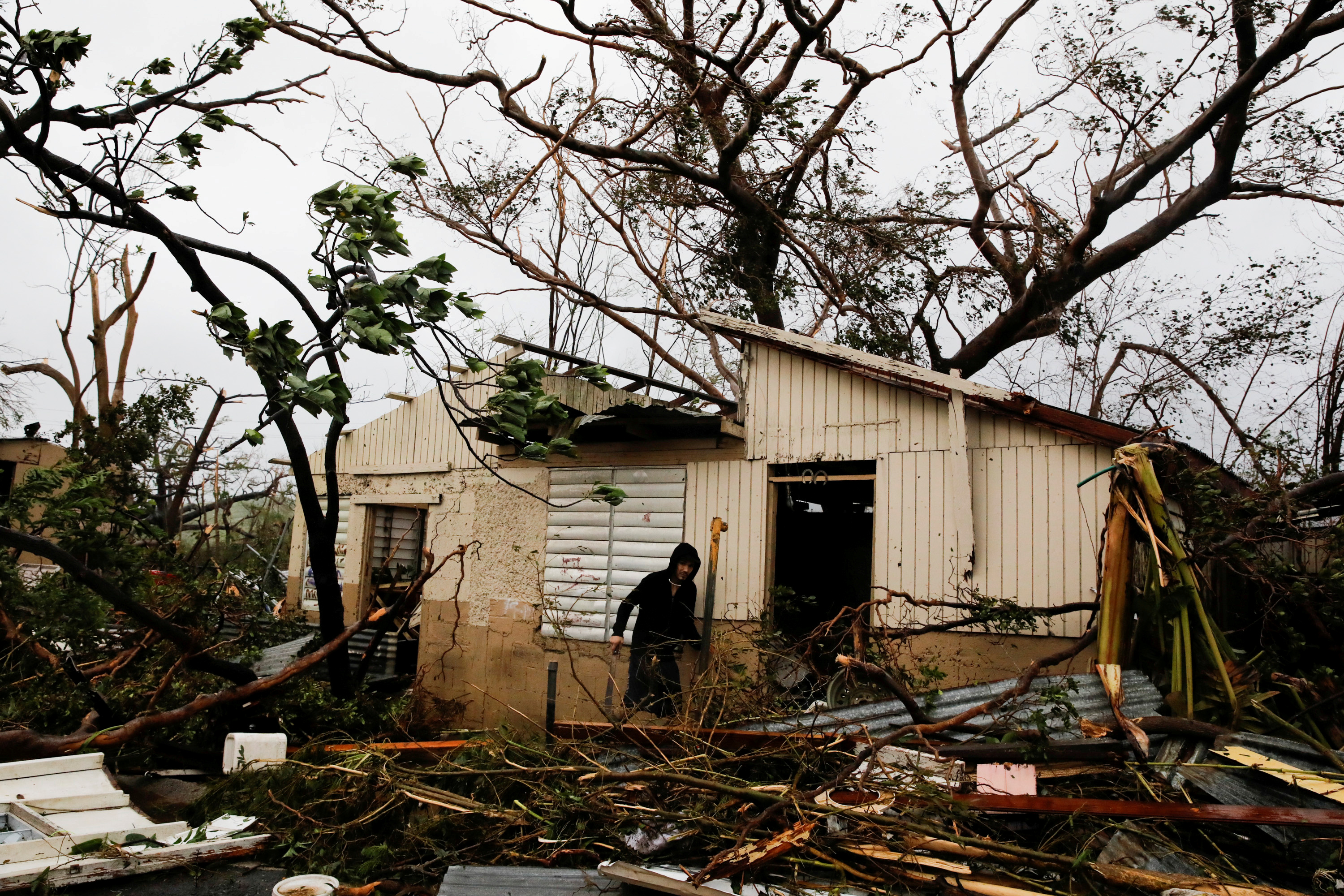 A man looks for valuables in the damaged house of a relative after the area was hit by Hurricane Maria in Guayama