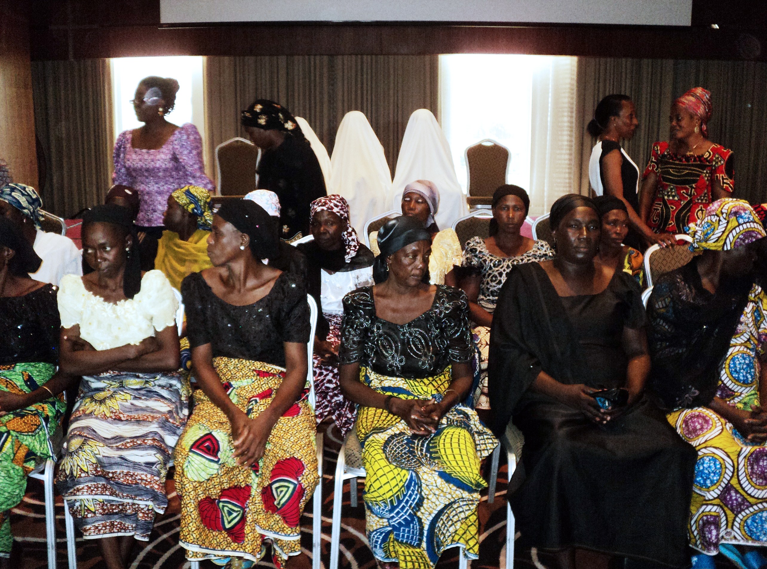 Nigerian mothers, with  some girls who escaped Boko Haram, are covered in sheets to hide their identity