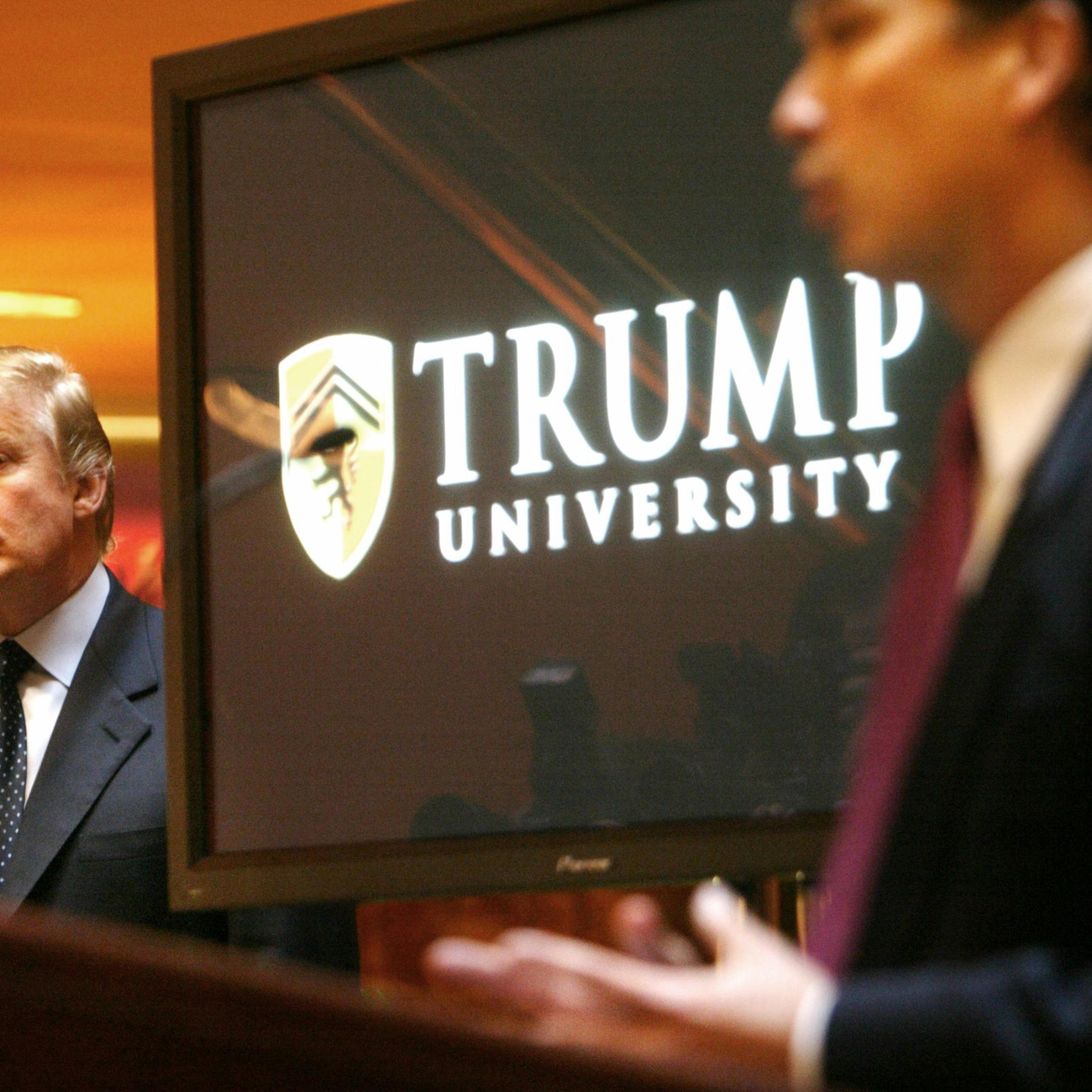 Donald Trump listens as Michael Sexton introduces him at a news conference in New York where he announced the establishment of Trump University on May 23, 2005.