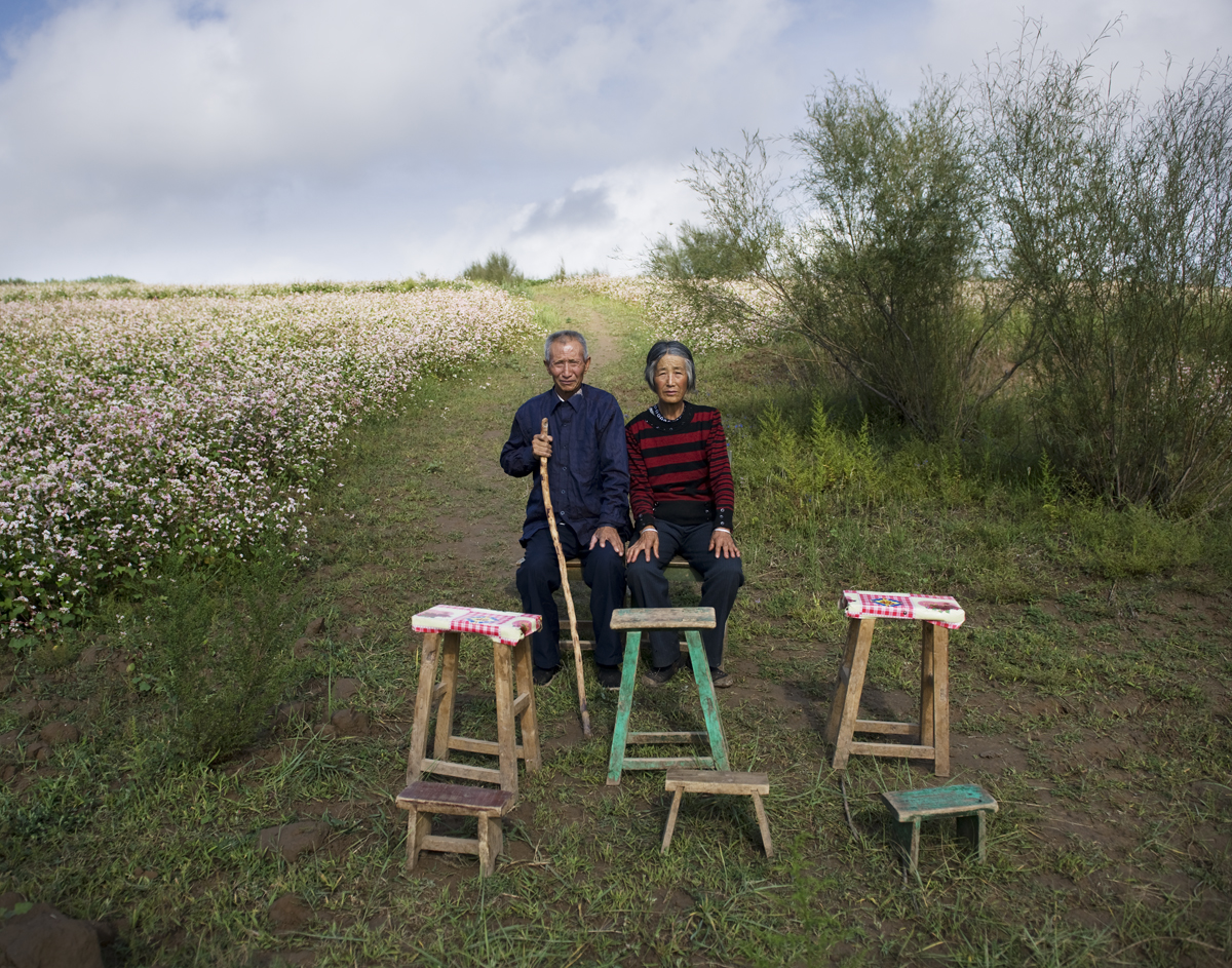Tian Yunxiu, 67 years old, and his wife Liu Dezhen sit in the farmland in Jingbian town, Shan’xi province, Aug. 24, 2011. Six family members travel to big cities to work as peasant workers.