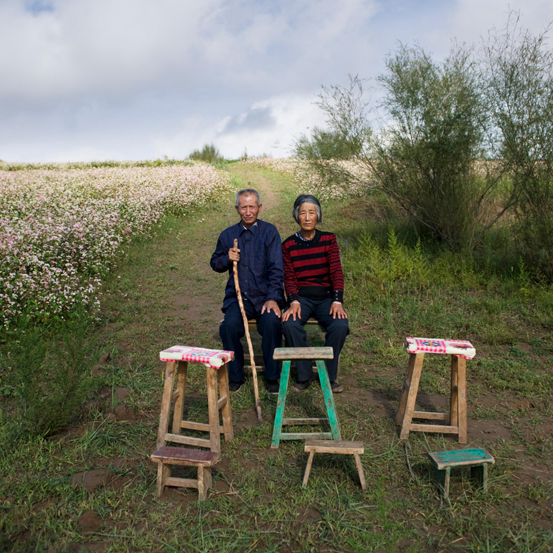 Tian Yunxiu, 67 years old, and his wife Liu Dezhen sit in the farmland in Jingbian town, Shan’xi province, Aug. 24, 2011. Six family members travel to big cities to work as peasant workers.