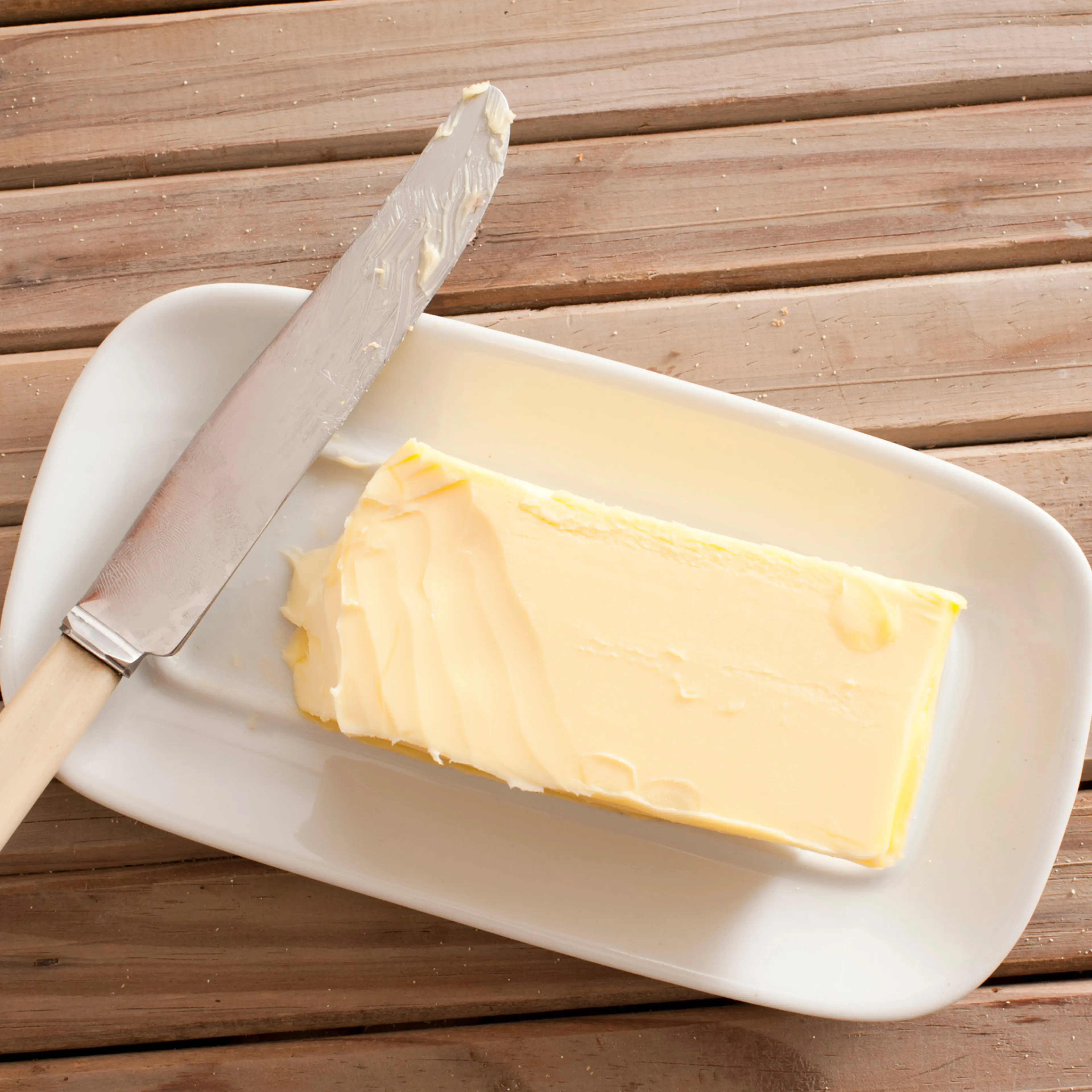Directly Above Shot Of Butter And Knife On Wooden Table