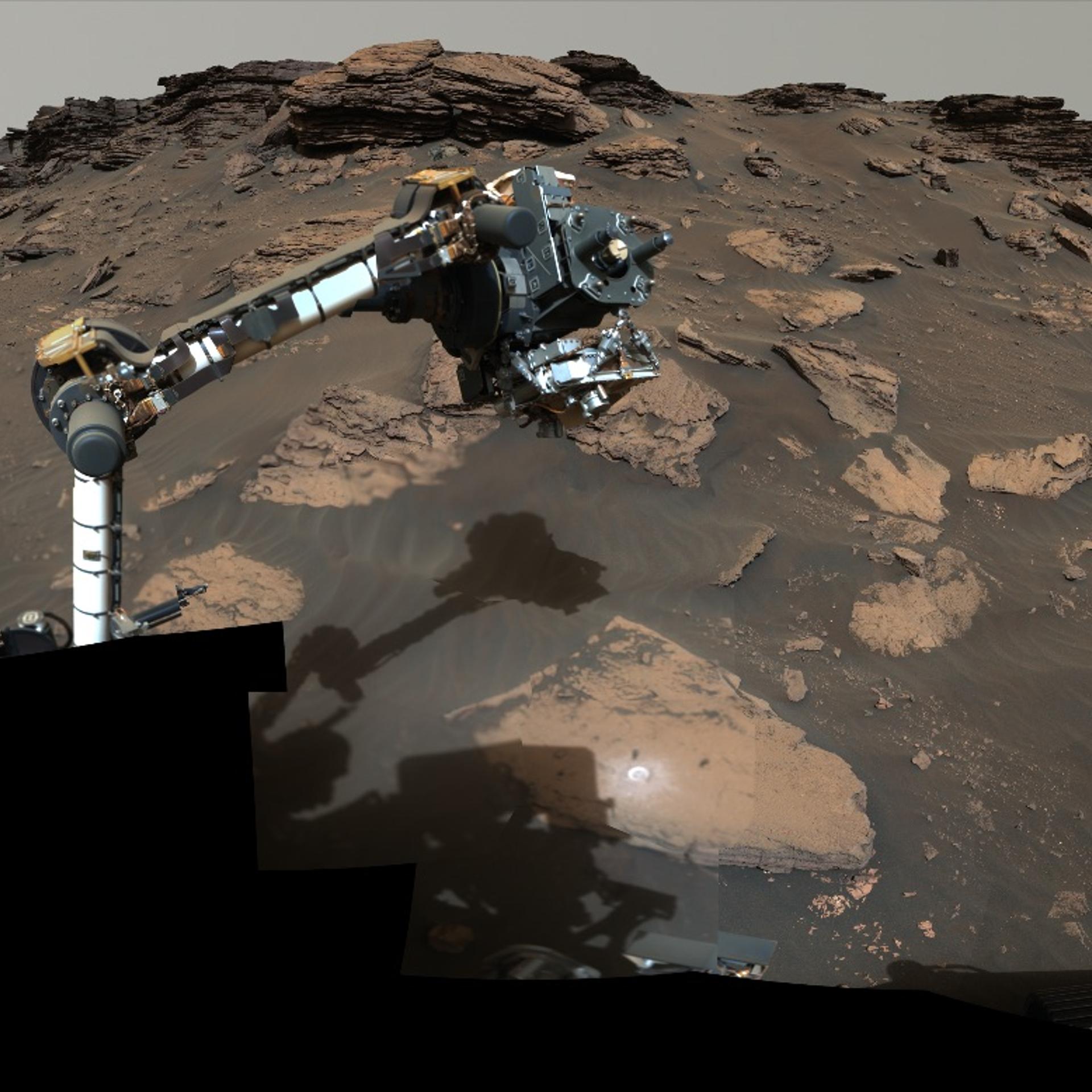 The Perseverance rover's robotic arm samples sedimentary material on Mars