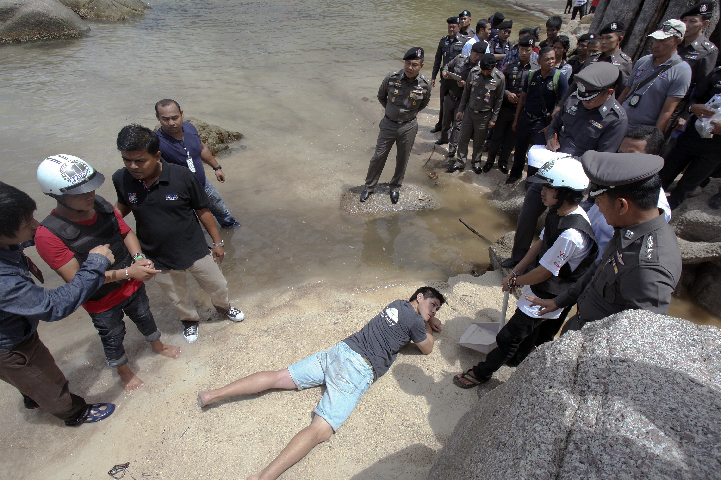 Two workers from Myanmar, suspected of killing two British tourists on the island of Koh Tao last month, stand during a re-enactment of the alleged crime, on the island