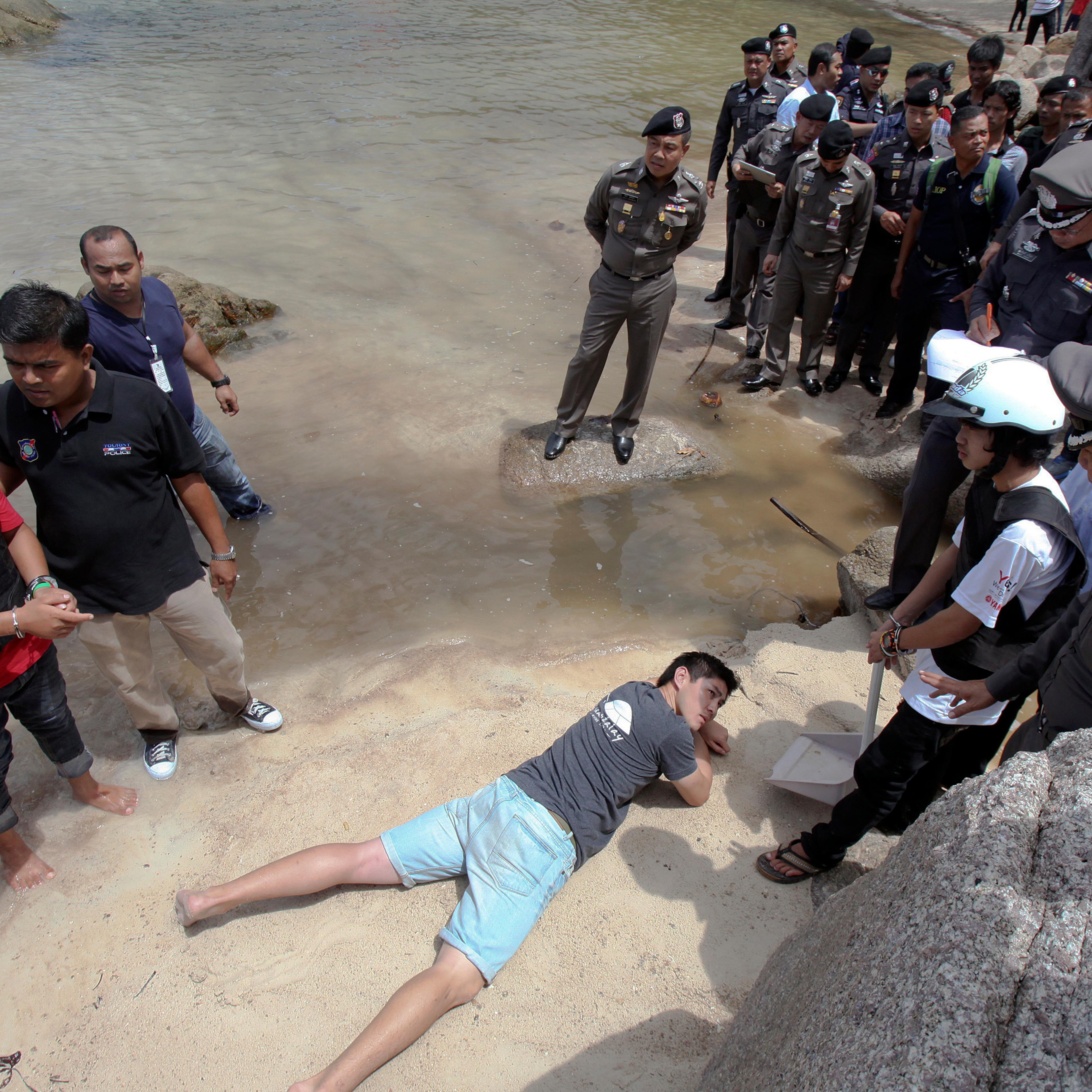 Two workers from Myanmar, suspected of killing two British tourists on the island of Koh Tao last month, stand during a re-enactment of the alleged crime, on the island