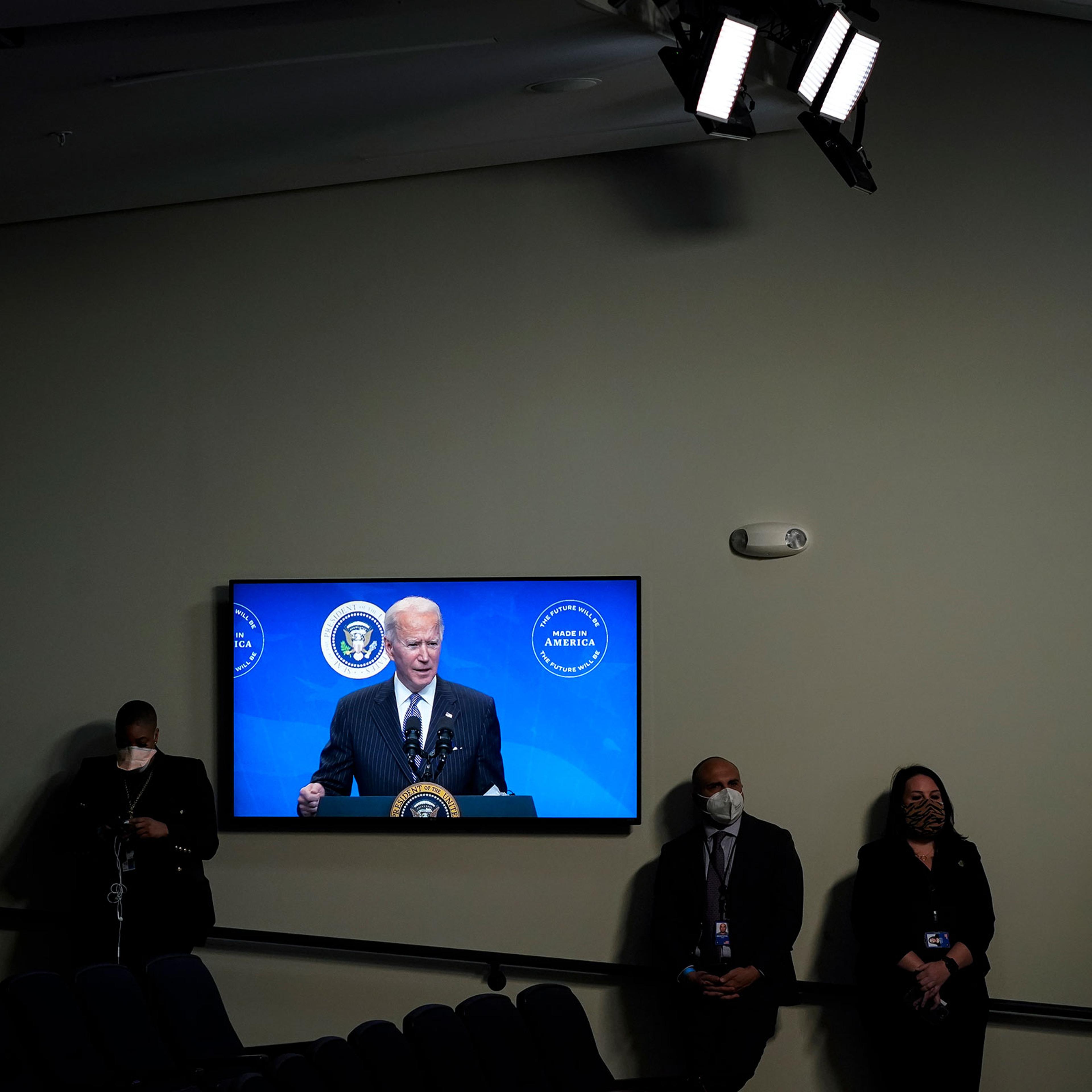 President Joe Biden is displayed on a screen while speaking after signing an executive order in the South Court Auditorium of the White House complex on Jan. 25, 2021.