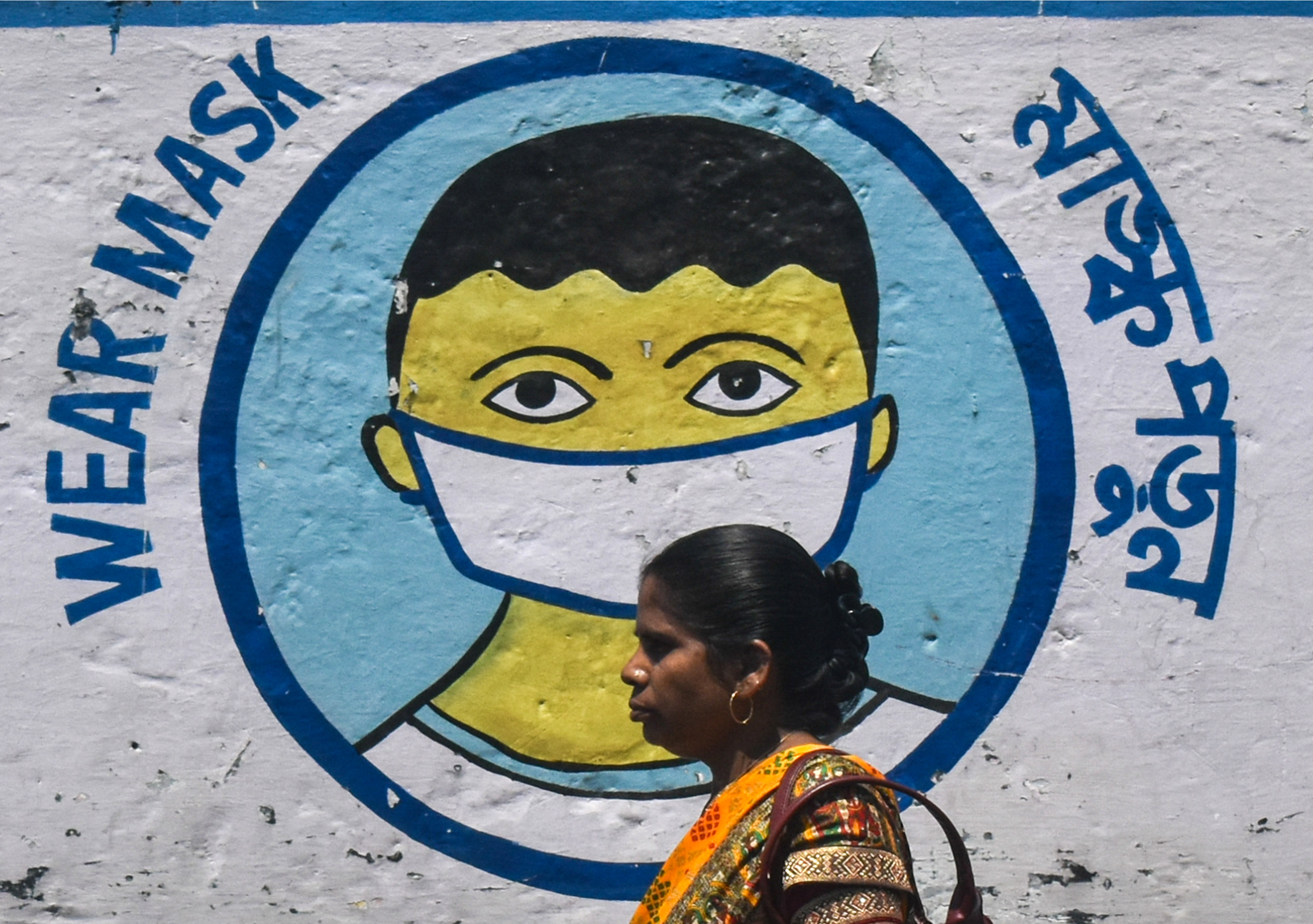A woman walks past a coronavirus-themed mural on a street amidst the spread of the coronavirus disease in Kolkata, India on Apr. 2