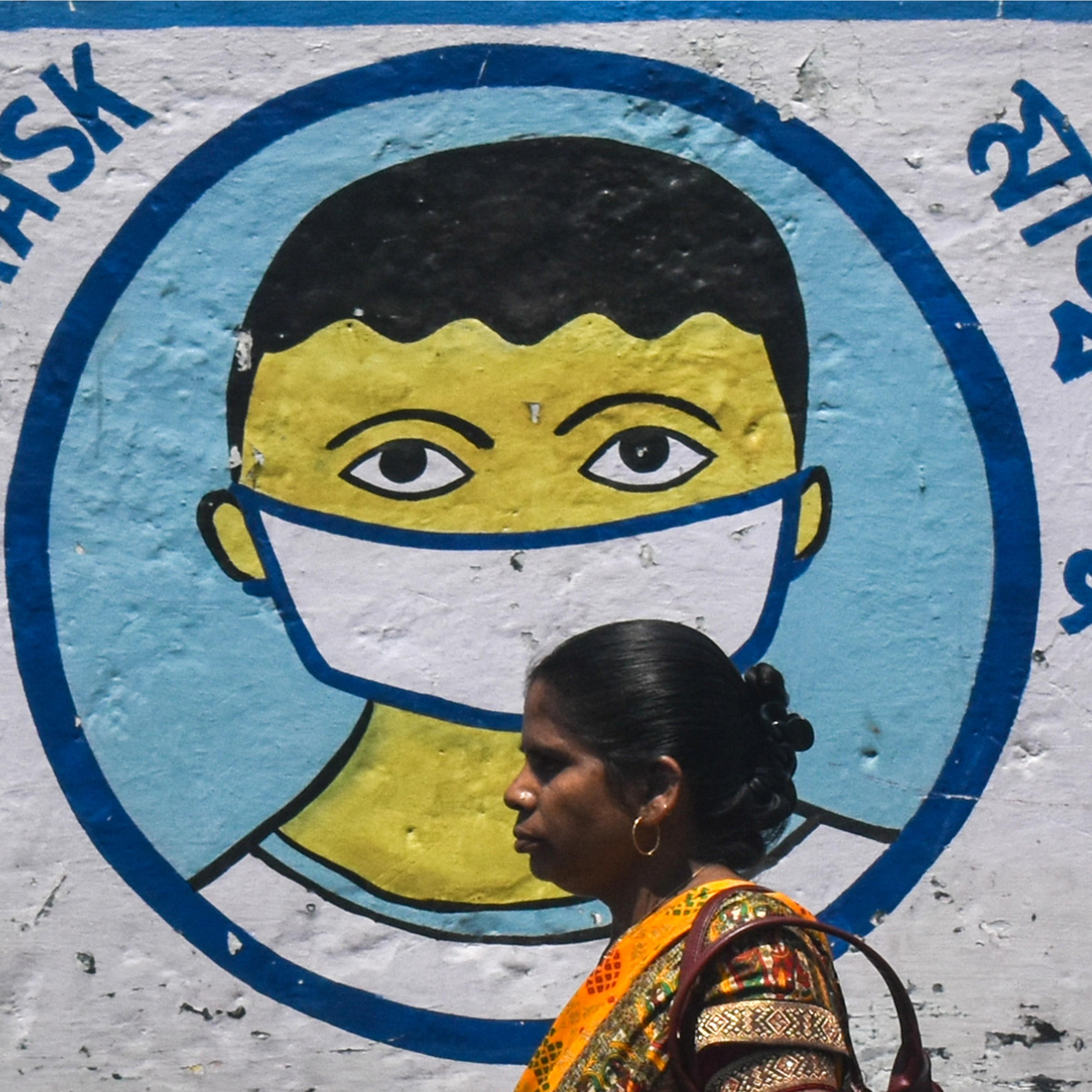 A woman walks past a coronavirus-themed mural on a street amidst the spread of the coronavirus disease in Kolkata, India on Apr. 2