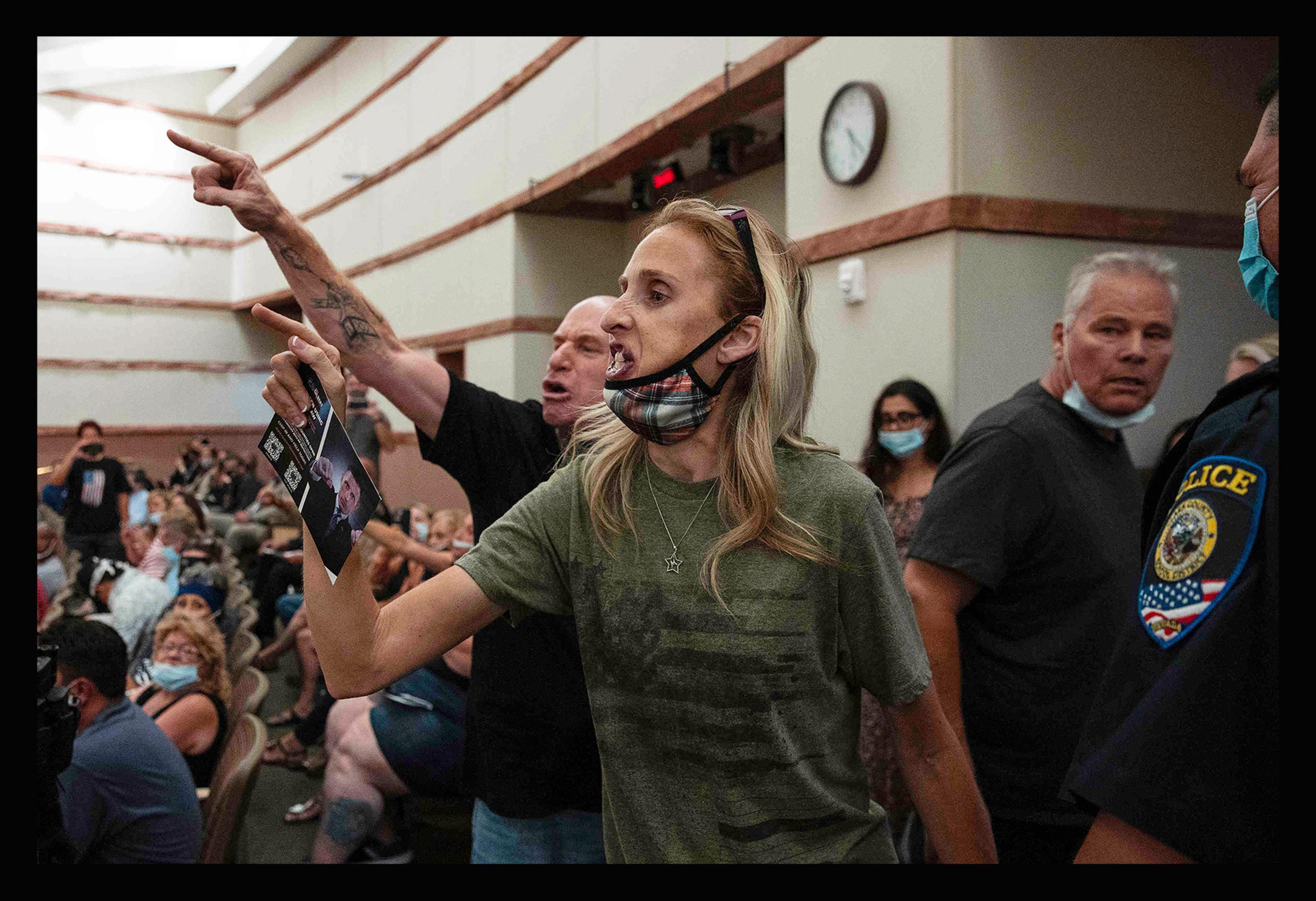Protesters against a COVID-19 mandate gesture as they are escorted out of the Clark County School Board meeting at the Clark County Government Center, in Las Vegas, on Aug. 12, 2021.