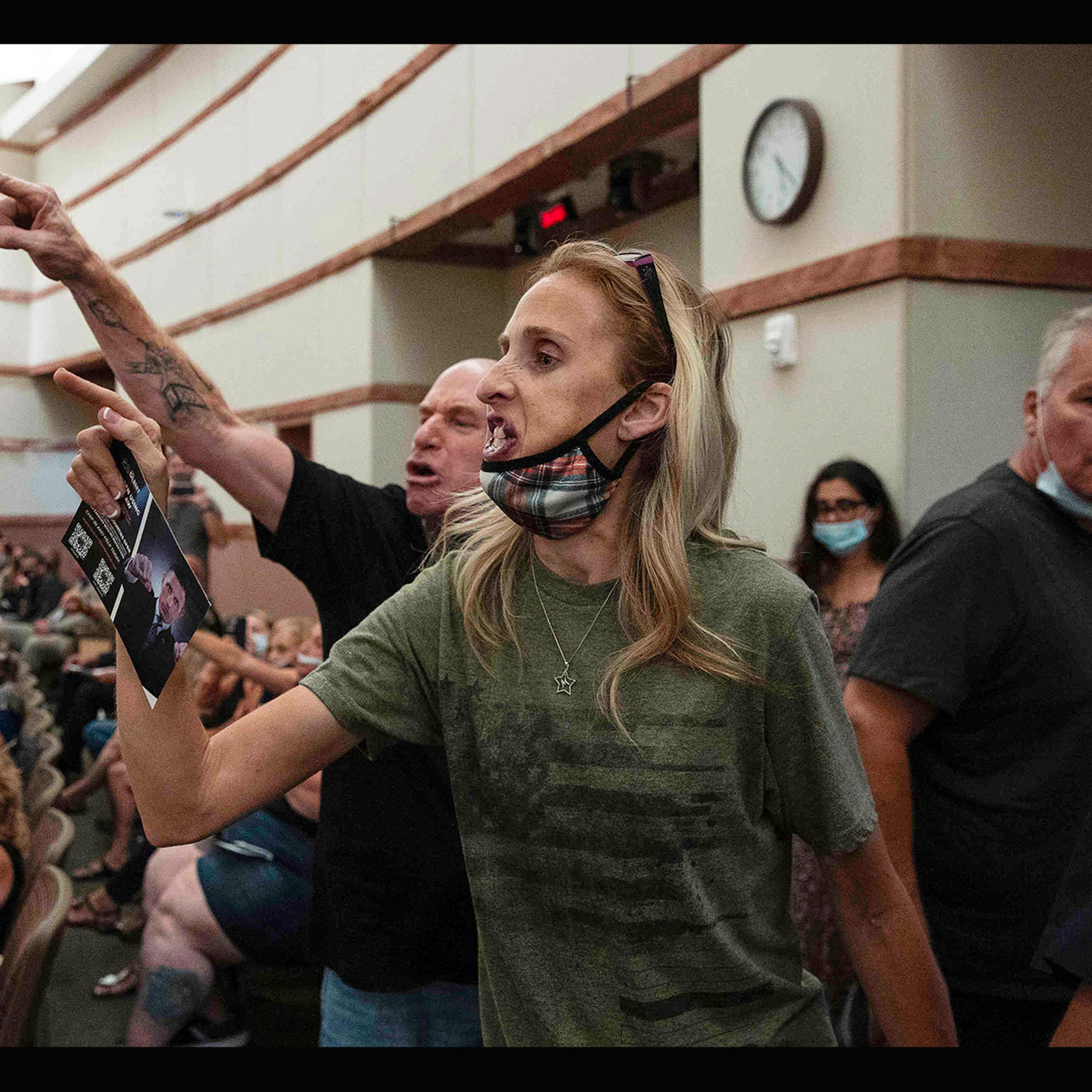 Protesters against a COVID-19 mandate gesture as they are escorted out of the Clark County School Board meeting at the Clark County Government Center, in Las Vegas, on Aug. 12, 2021.