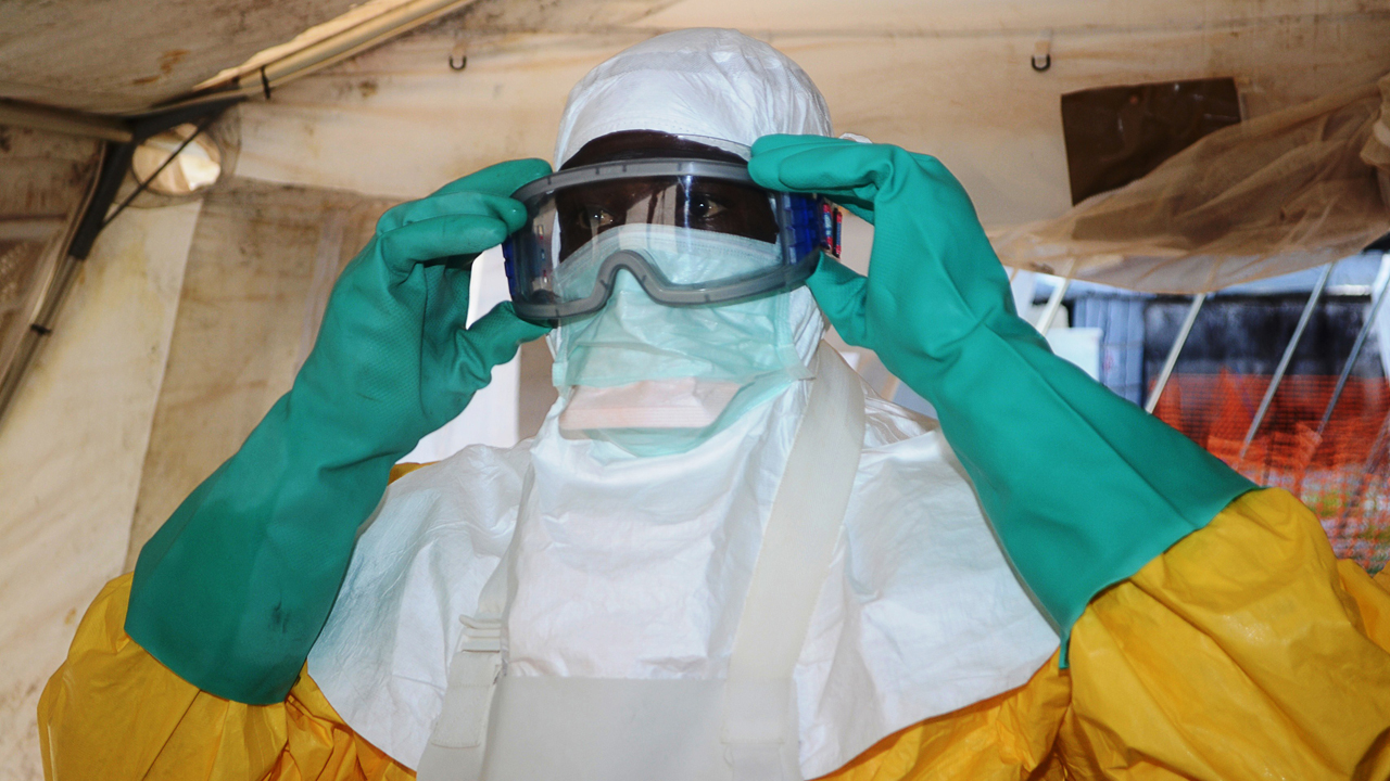A member of Doctors Without Borders puts on protective gear in a Conakry hospital on Conakry, Guinea on June 28, 2013.