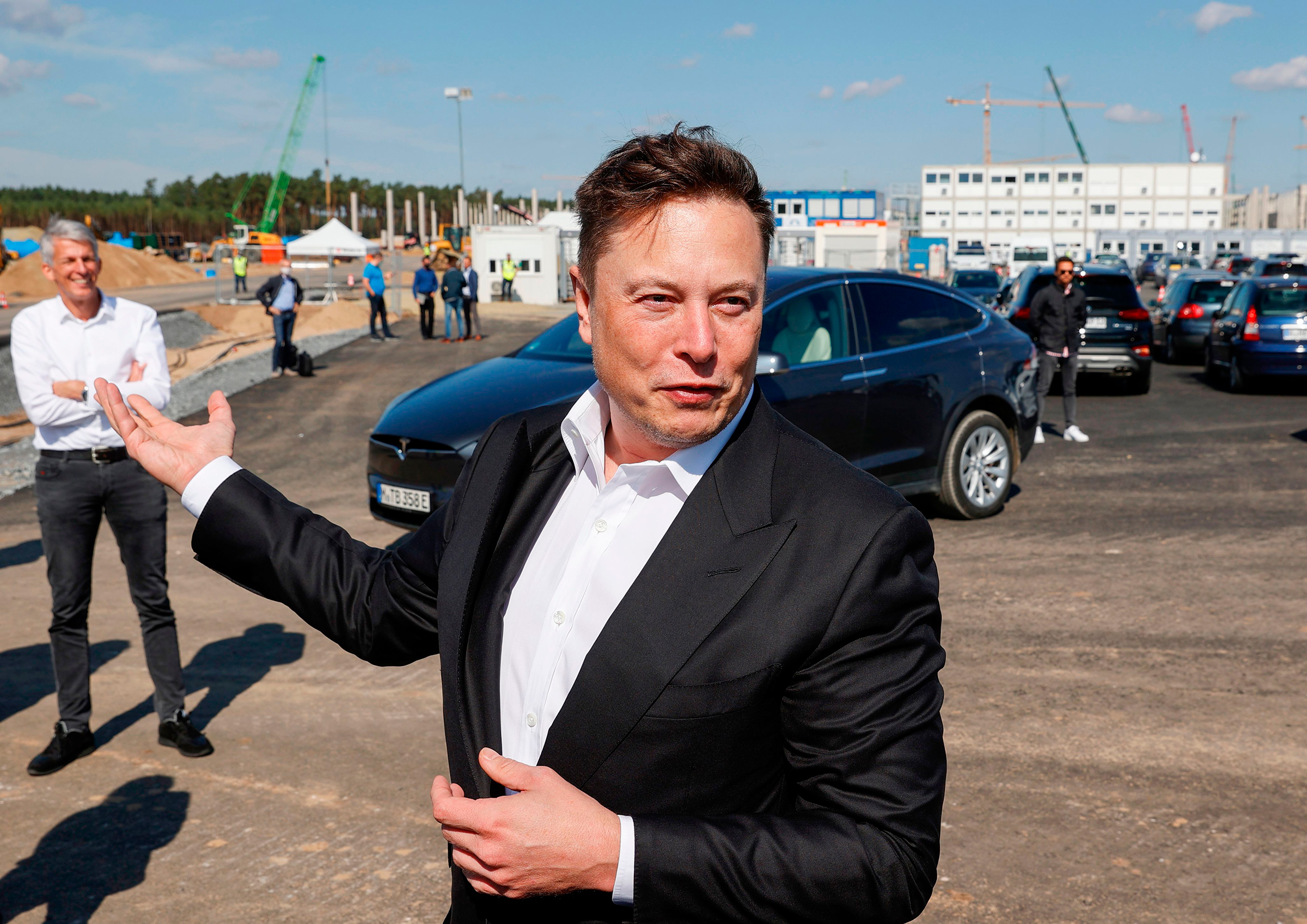 Tesla CEO Elon Musk talks to media as he arrives to visit the construction site of the future US electric car giant Tesla, on September 03, 2020 in Gruenheide near Berlin.