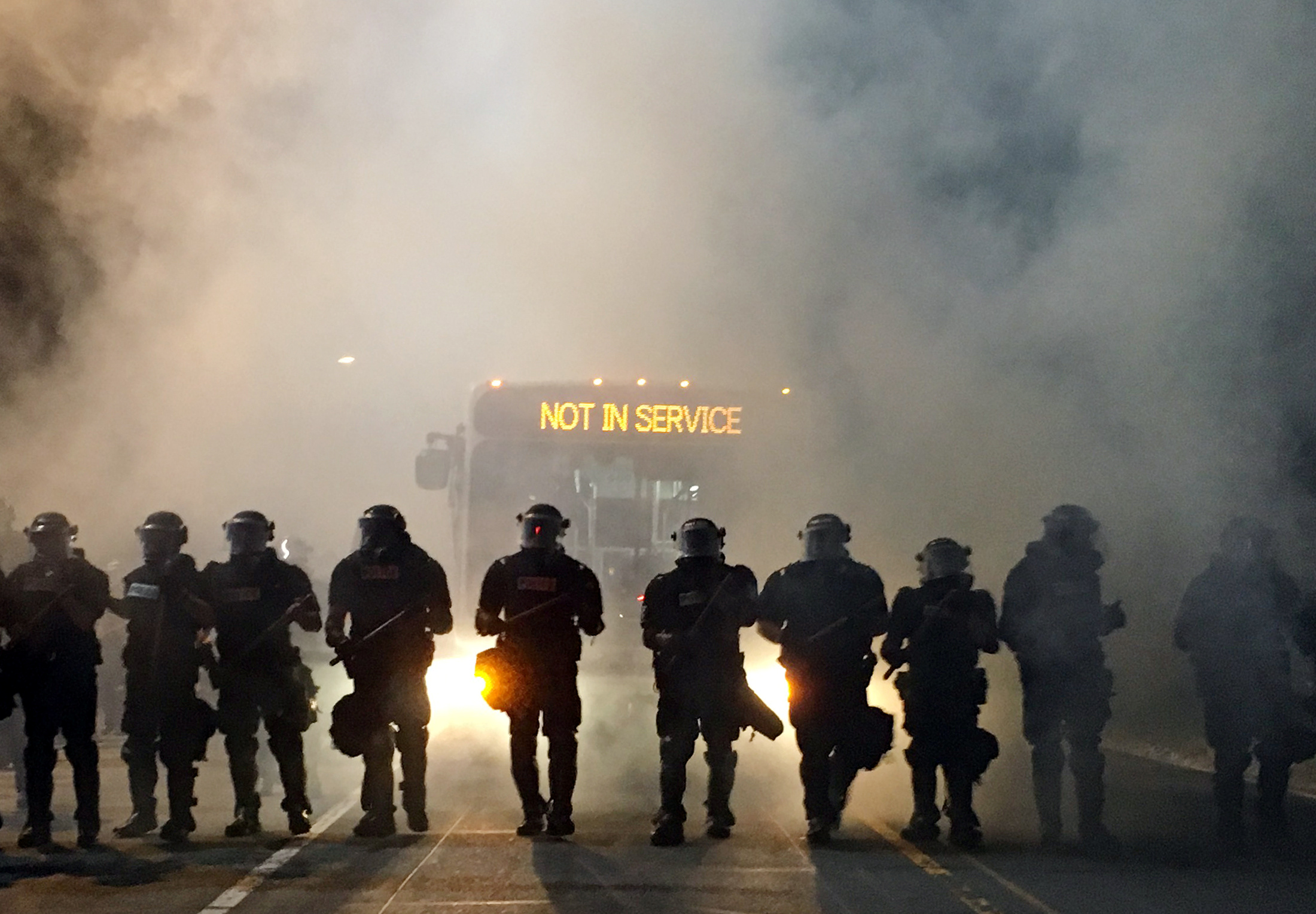 Police officers wearing riot gear block a road during protests after police fatally shot a man in the parking lot of an apartment complex in Charlotte