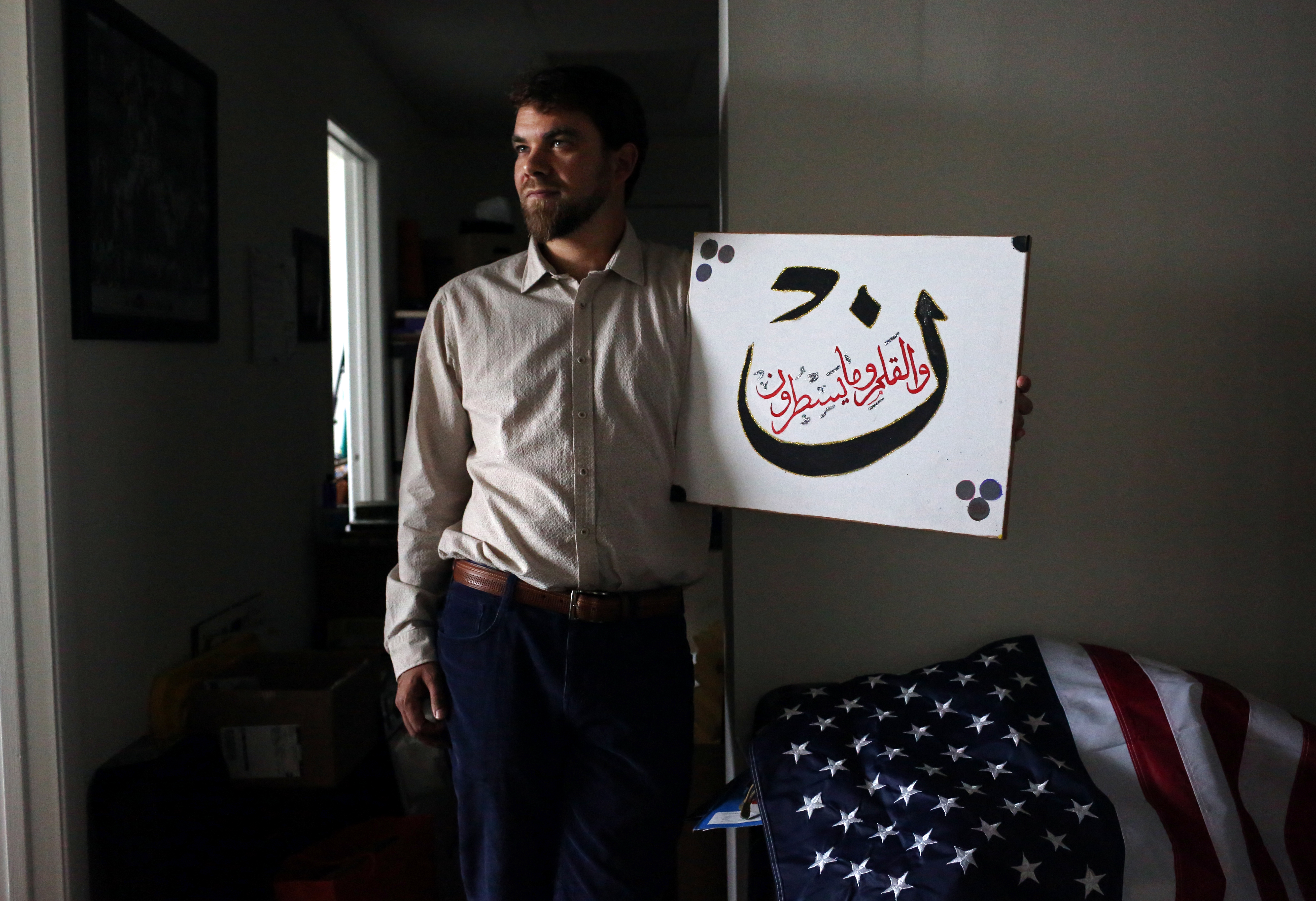 Adam Warshauer, 37, from Delray Beach, FL, whose father is Jewish and mother is a Christian, became a Sufi Muslim after being introduced to the faith by a man he met at 22. He is seen here posing for a portrait with a verse of the Koran, in a just-moved-
