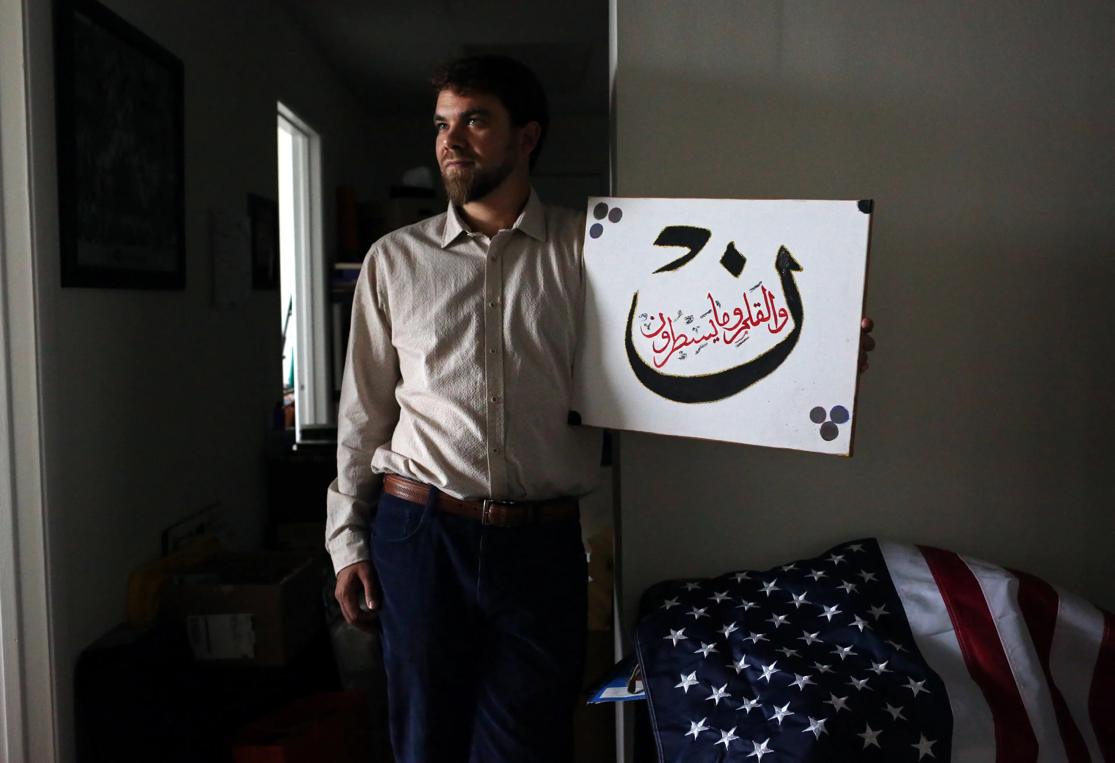 Adam Warshauer, 37, from Delray Beach, FL, whose father is Jewish and mother is a Christian, became a Sufi Muslim after being introduced to the faith by a man he met at 22. He is seen here posing for a portrait with a verse of the Koran, in a just-moved-