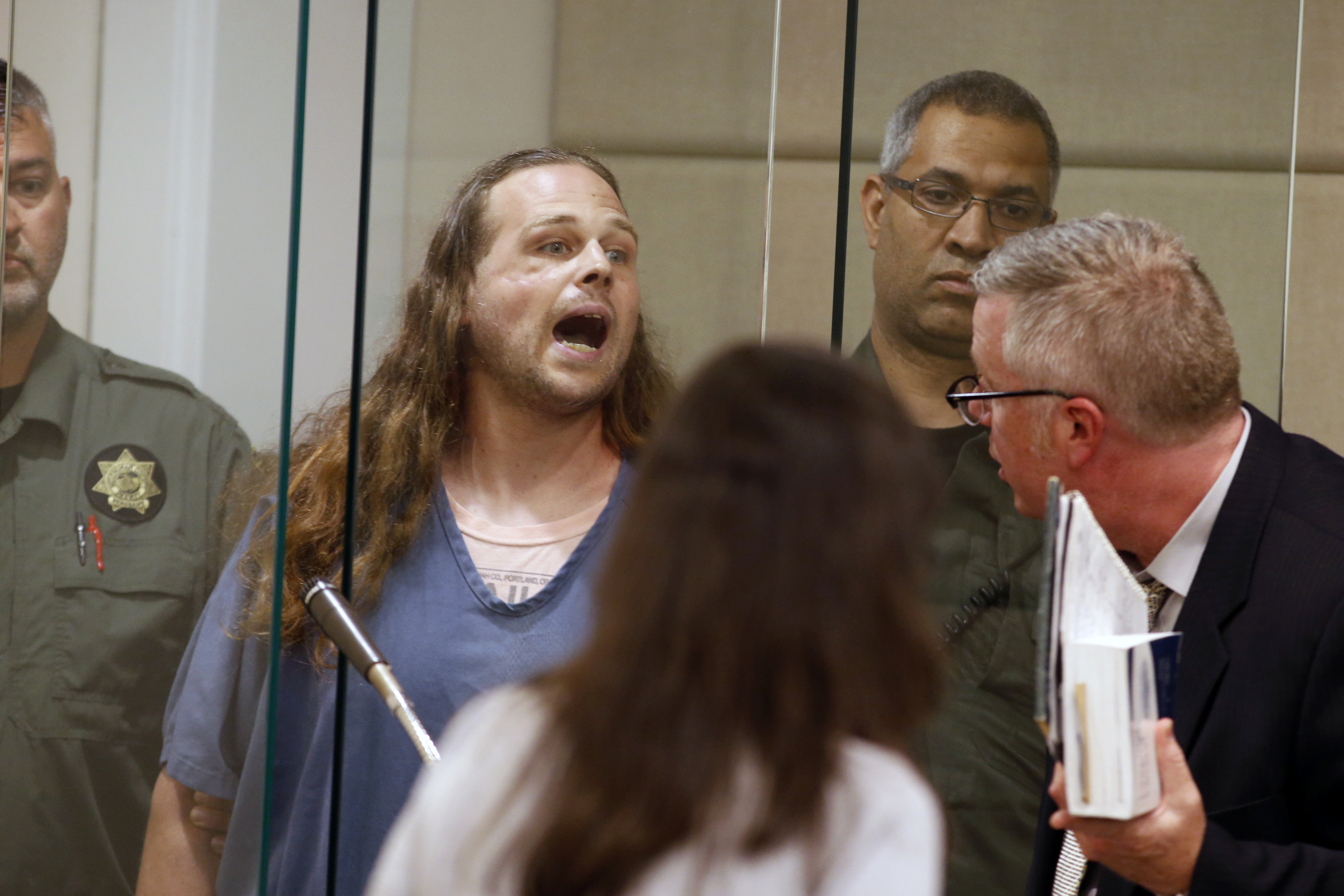 Jeremy Joseph Christian shouts as he is arraigned in Multnomah County Circuit Court in Portland, Ore., Tuesday, May 30, 2017. Authorities say Christian started verbally abusing two young women, including one wearing a hijab. When three men on the train i