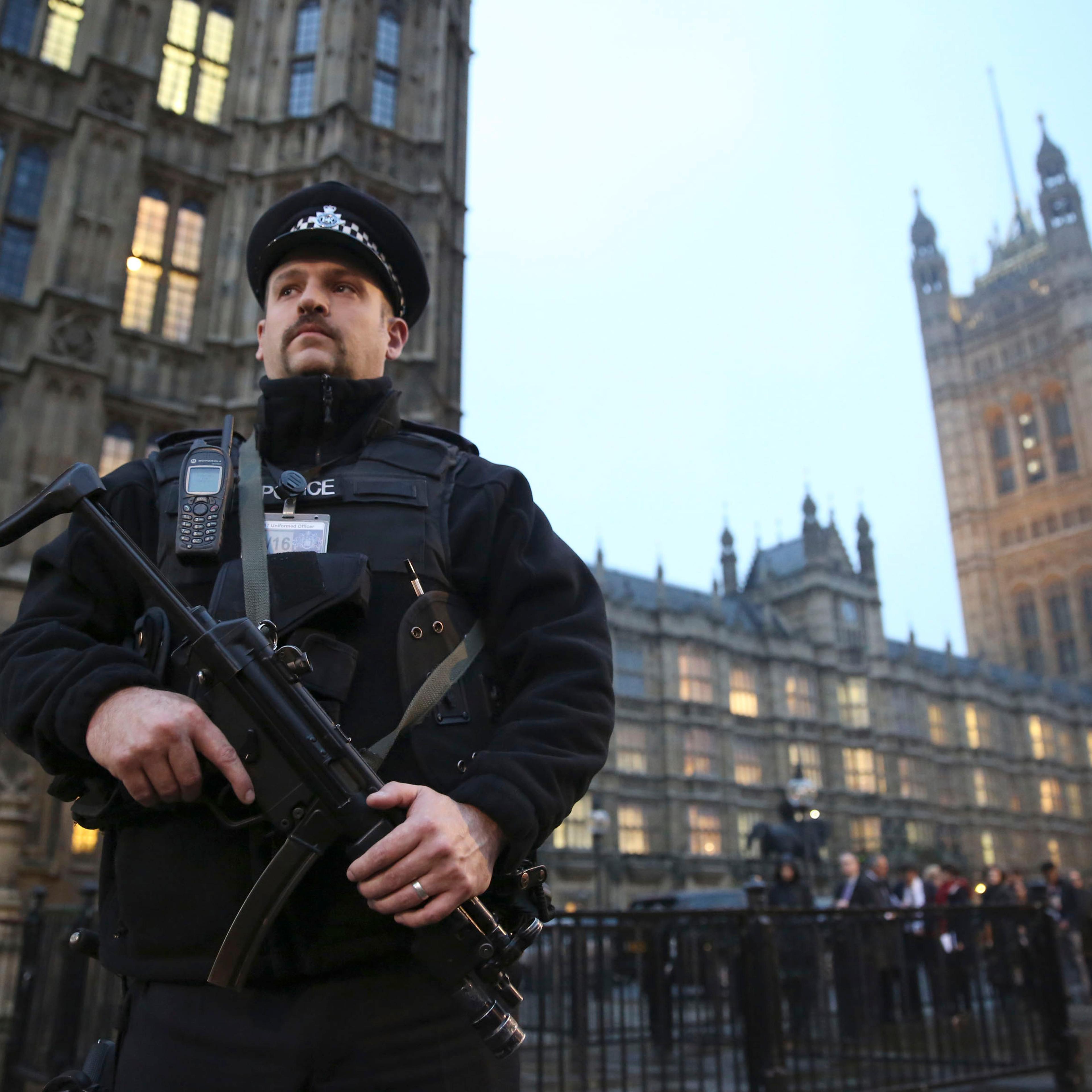 An armed police officer stands outside the Houses of Parliament, central London