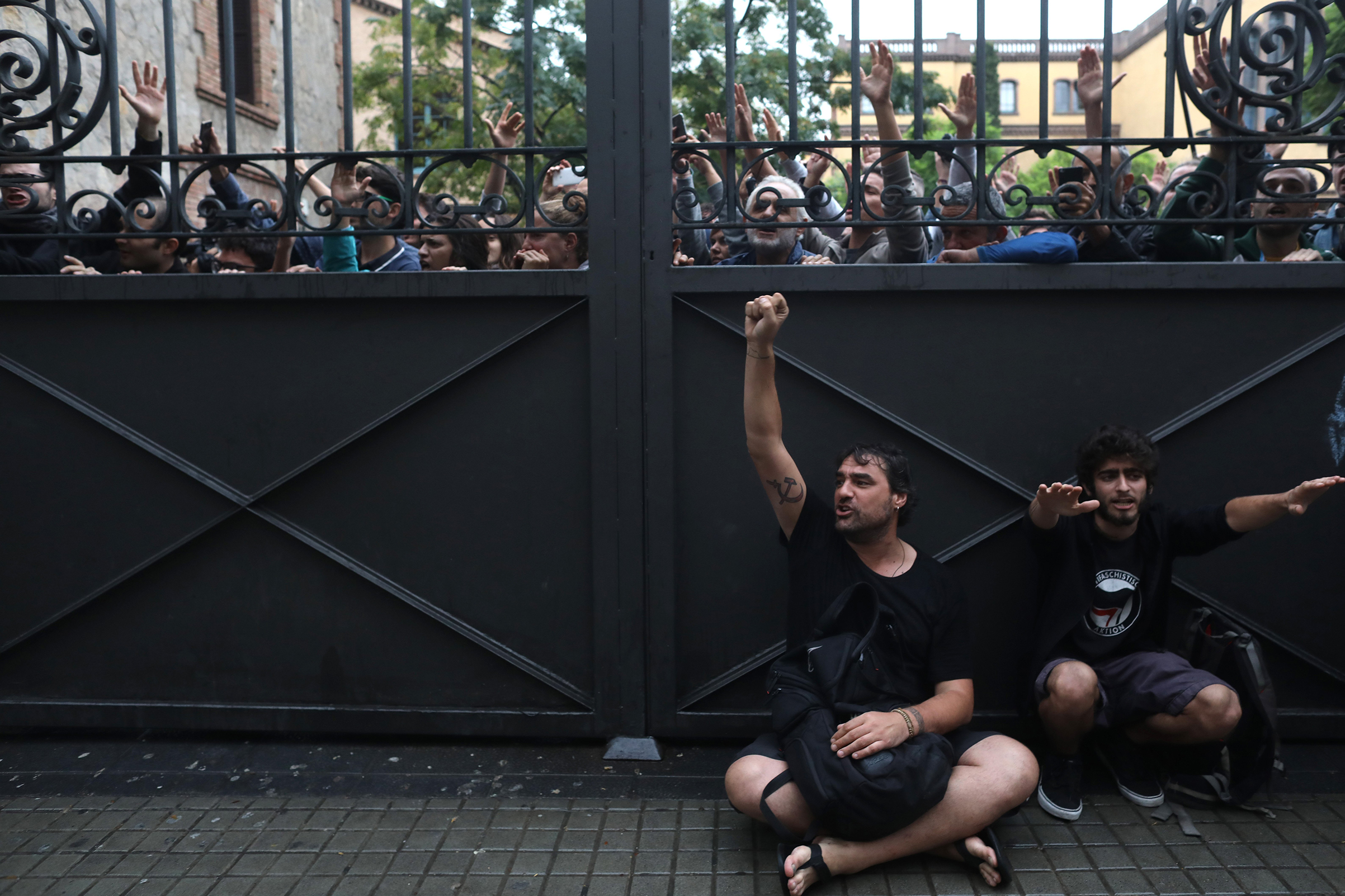A gate locks people out as police try to control the area where people wait to cast their ballot in the referendum vote at Escola Industrial of Barcelona polling station on Oct. 1, 2017.