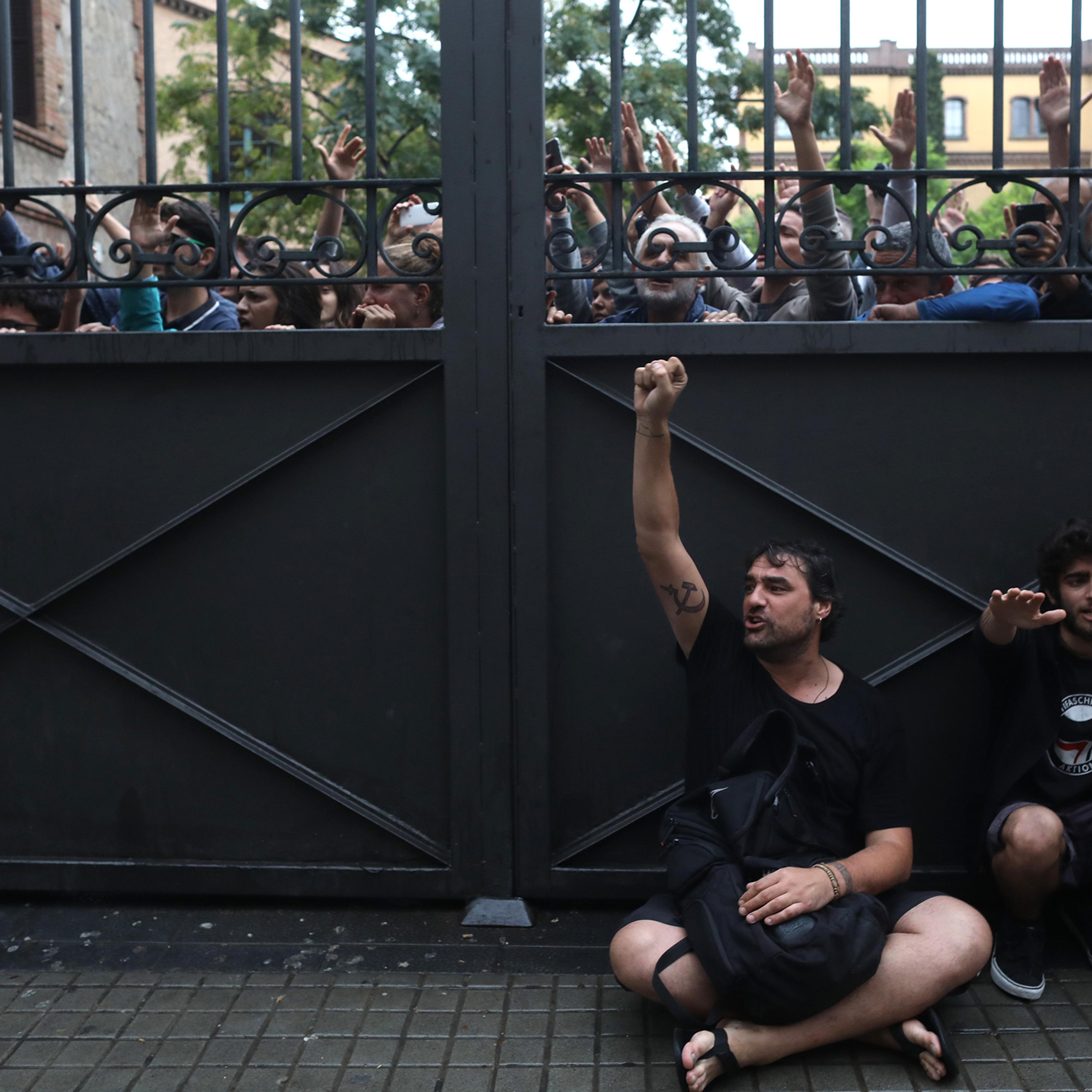 A gate locks people out as police try to control the area where people wait to cast their ballot in the referendum vote at Escola Industrial of Barcelona polling station on Oct. 1, 2017.