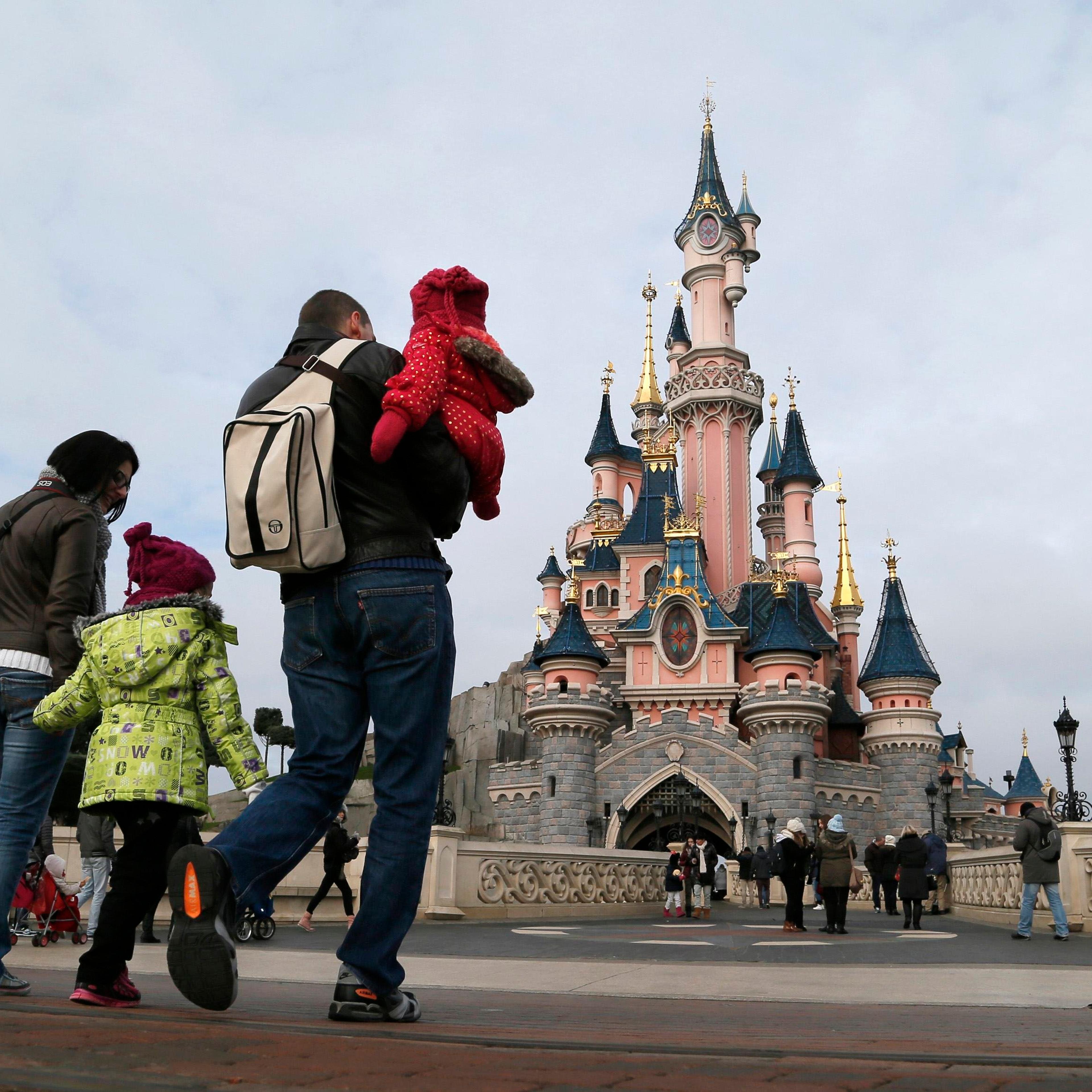 Visitors walk towards the Sleeping Beauty Castle during a visit to the Disneyland Paris Resort run by EuroDisney S.C.A in Marne-la-Vallee on Jan. 21, 2015.