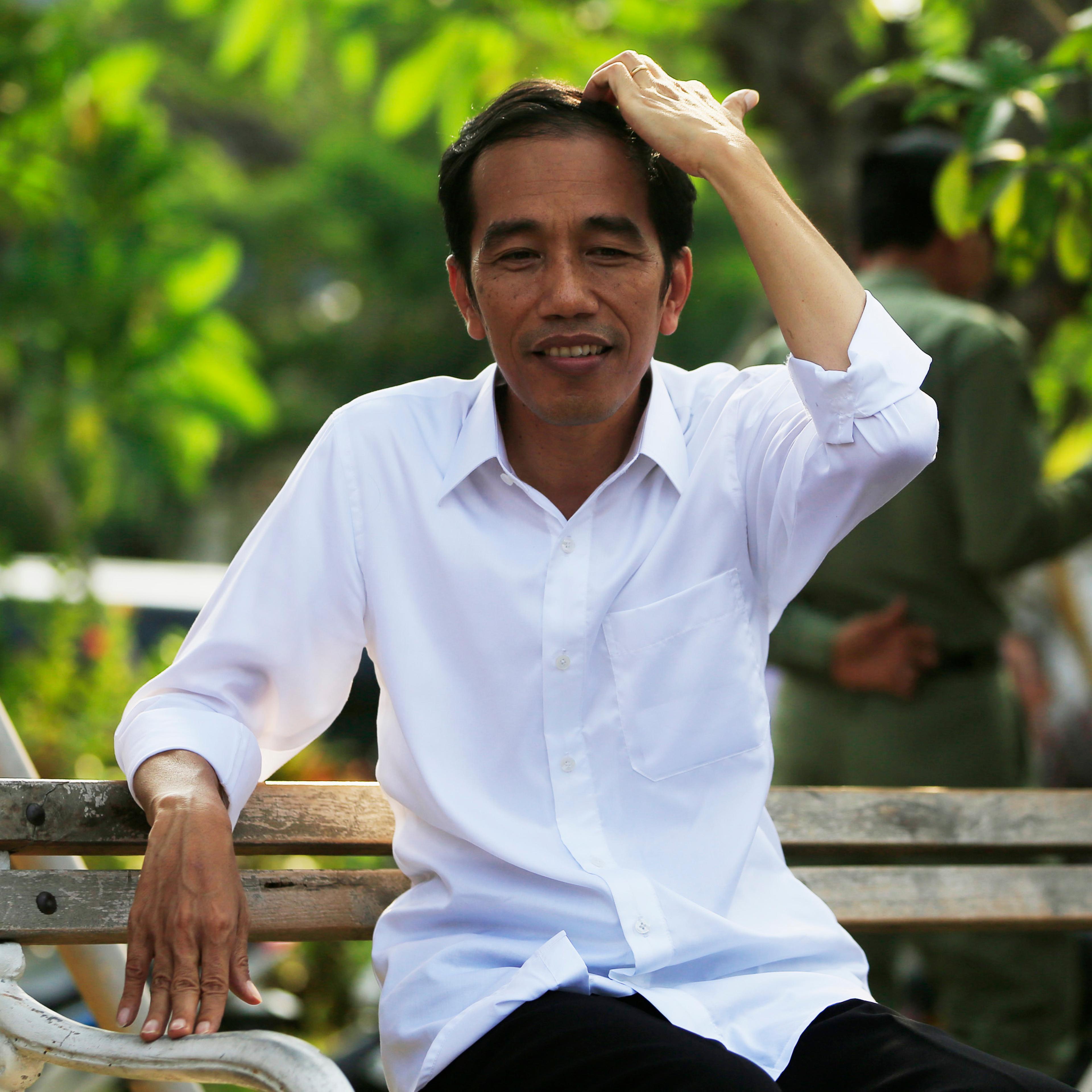 Indonesian presidential candidate Jokowi sits on a bench while waiting for the announcement of the results from the Elections Commission at Waduk Pluit in Jakarta
