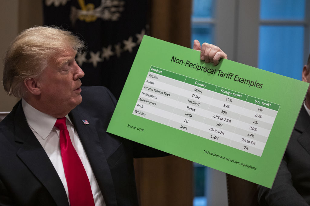 U.S. President Donald Trump speaks while holding a chart