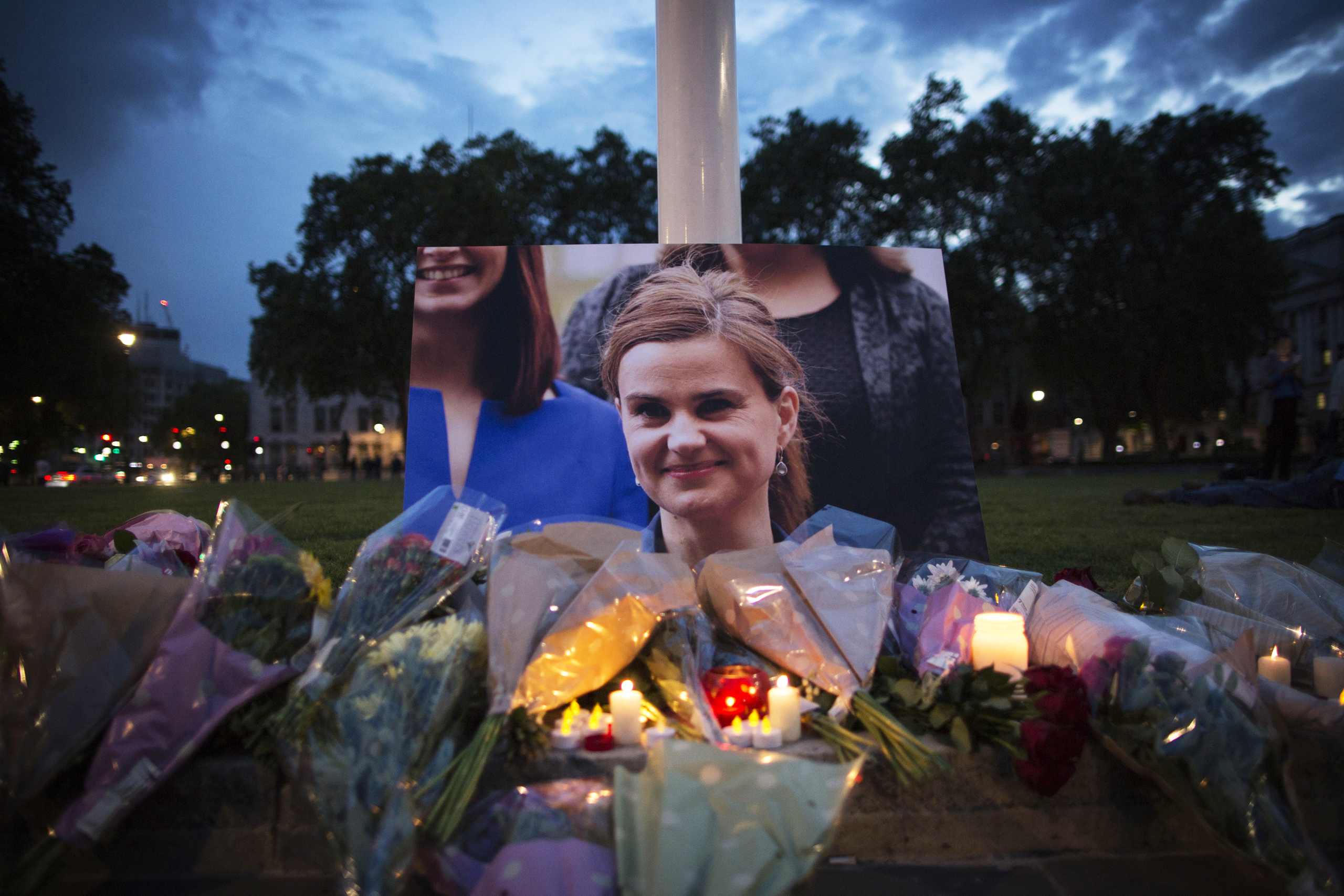 Flowers surround a picture of Jo Cox during a vigil in Parliament Square on June 16, 2016. The trial of the man suspected of killing Cox, Thomas Mair, started this week.