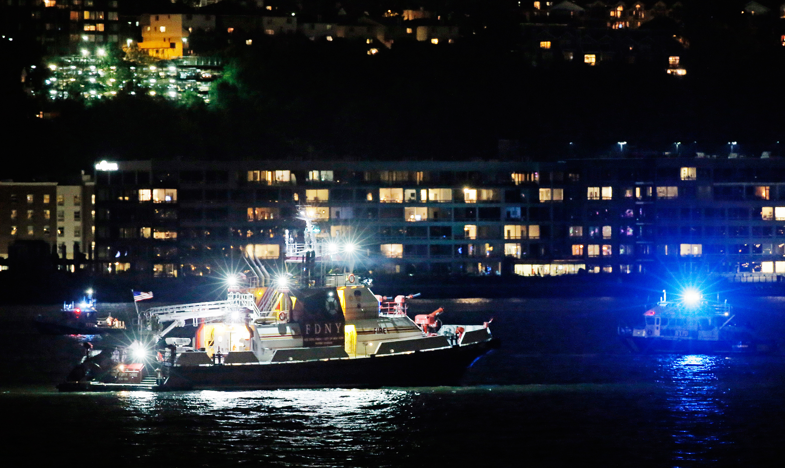 An FDNY fire department boat searches the Hudson River for the wreckage of a vintage P-47 Thunderbolt airplane that crashed in the river in New York City, May 27, 2016.