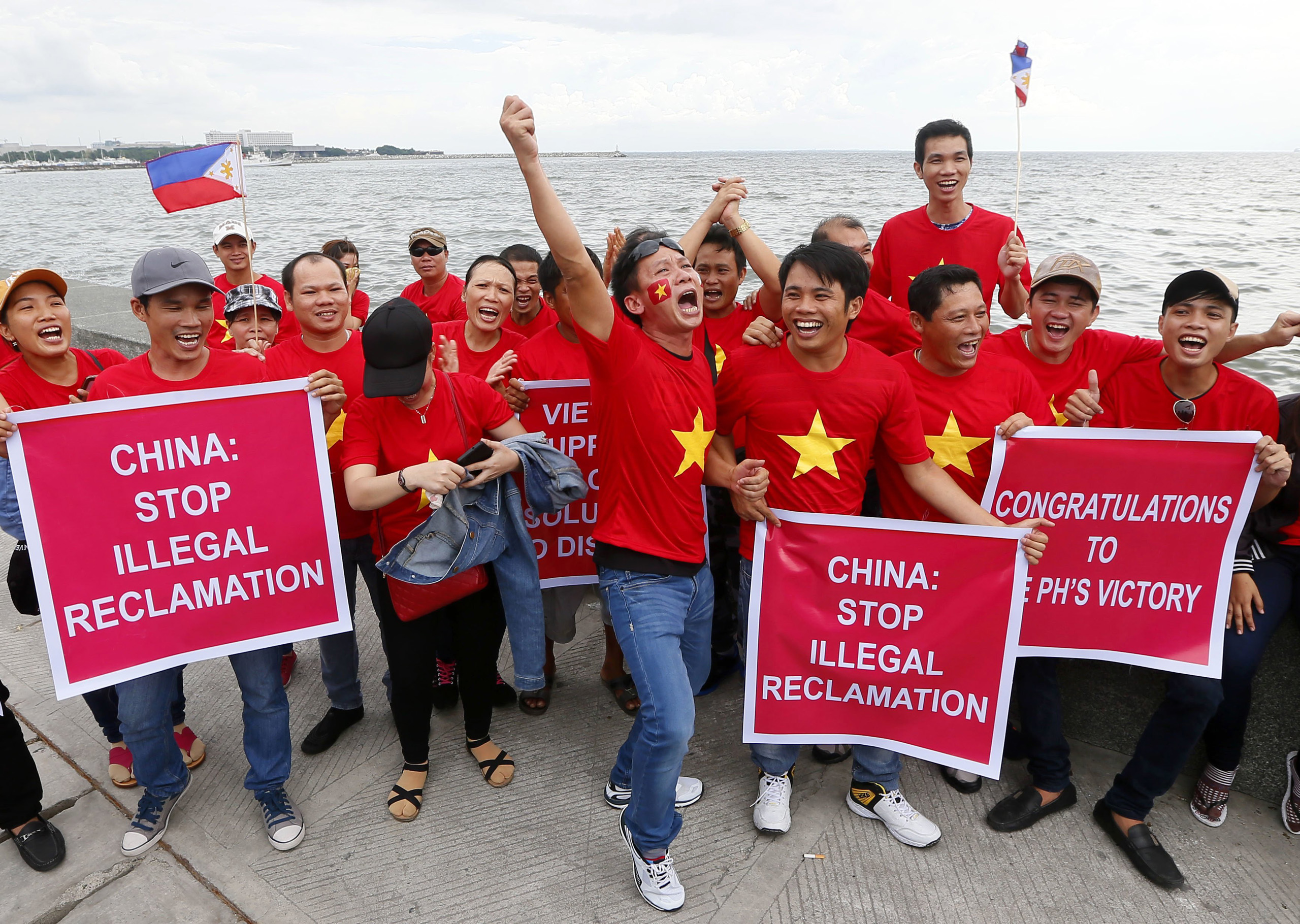 Vietnamese expatriates cheer while displaying placards during a rally by the Manila's baywalk before the Hague-based U.N. international arbitration tribunal is to announce its ruling on South China Sea in the Philippines on July 12, 2016.