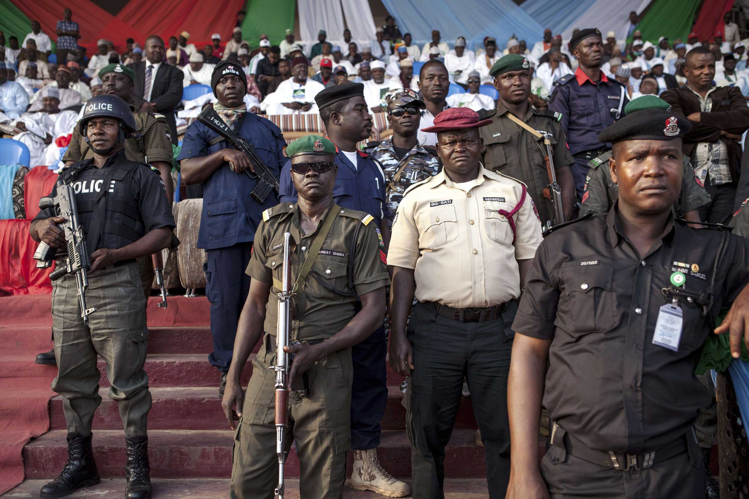 Policemen and soldiers guard during a rally of the main Nigerian opposition All Progressive Congress party in Kaduna, Nigeria on Jan. 19, 2015.