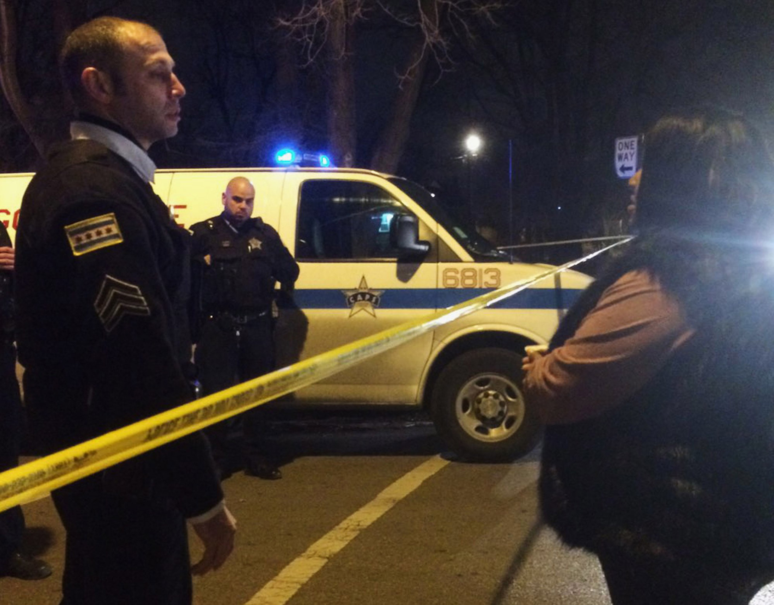 A Chicago police sergeant speaks with a relative of a man who was killed by a police officer in the West Garfield Park neighborhood in Chicago, early Saturday, Dec. 26, 2015. A Chicago police officer shot and killed two people while responding to a domes
