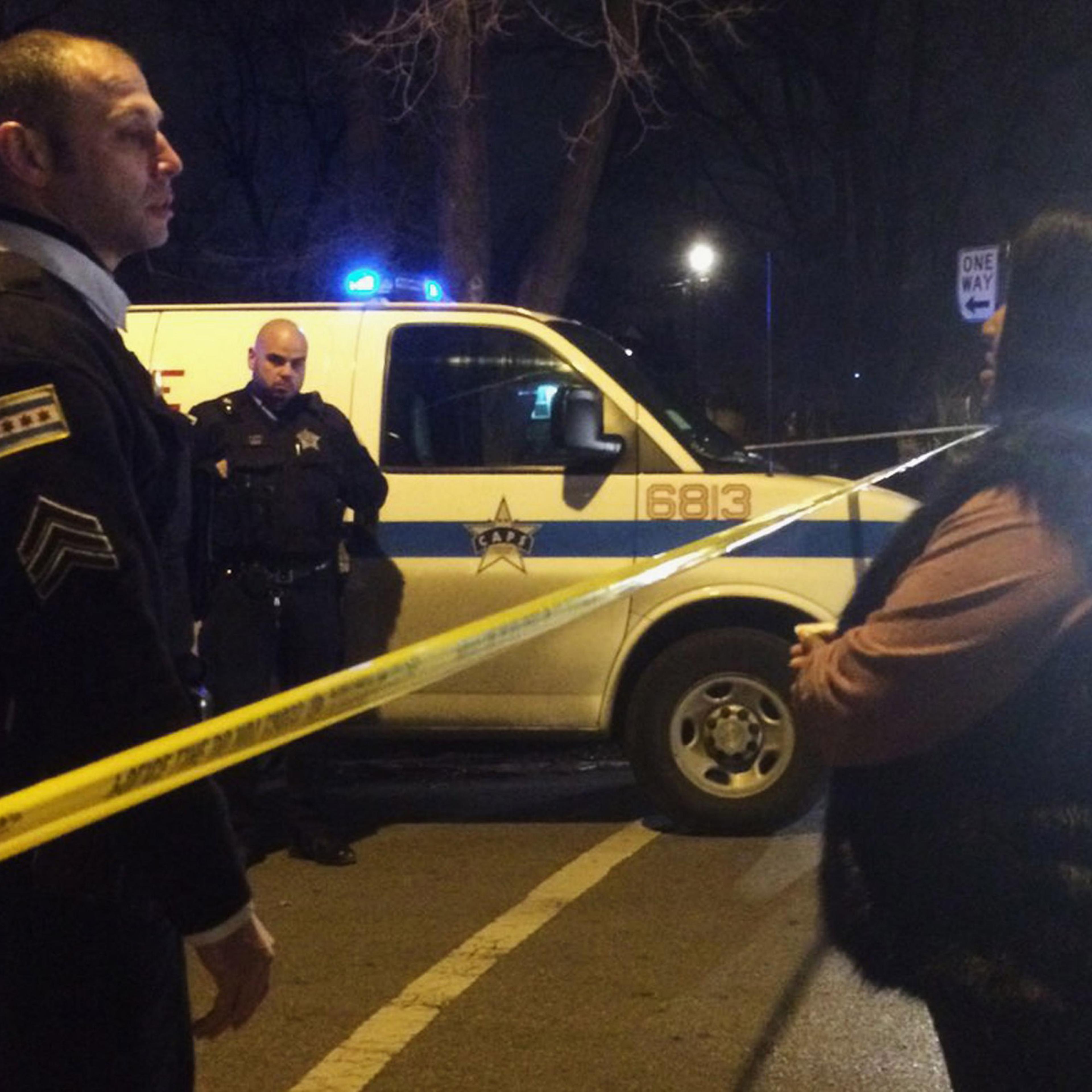 A Chicago police sergeant speaks with a relative of a man who was killed by a police officer in the West Garfield Park neighborhood in Chicago, early Saturday, Dec. 26, 2015. A Chicago police officer shot and killed two people while responding to a domes