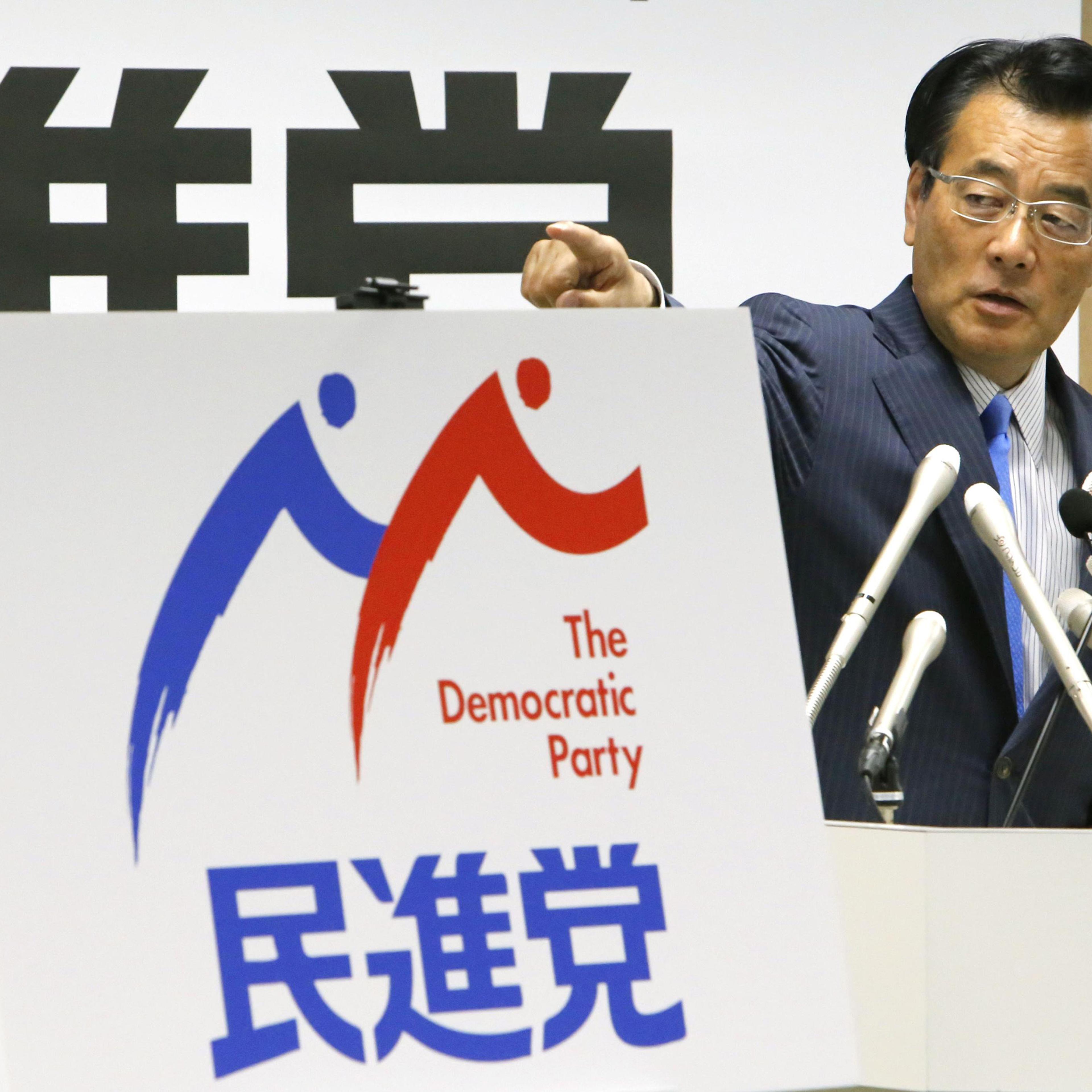 Katsuya Okada, leader of the main opposition Democratic Party, unveils the party's logo at a press conference in Tokyo on May 19, 2016.