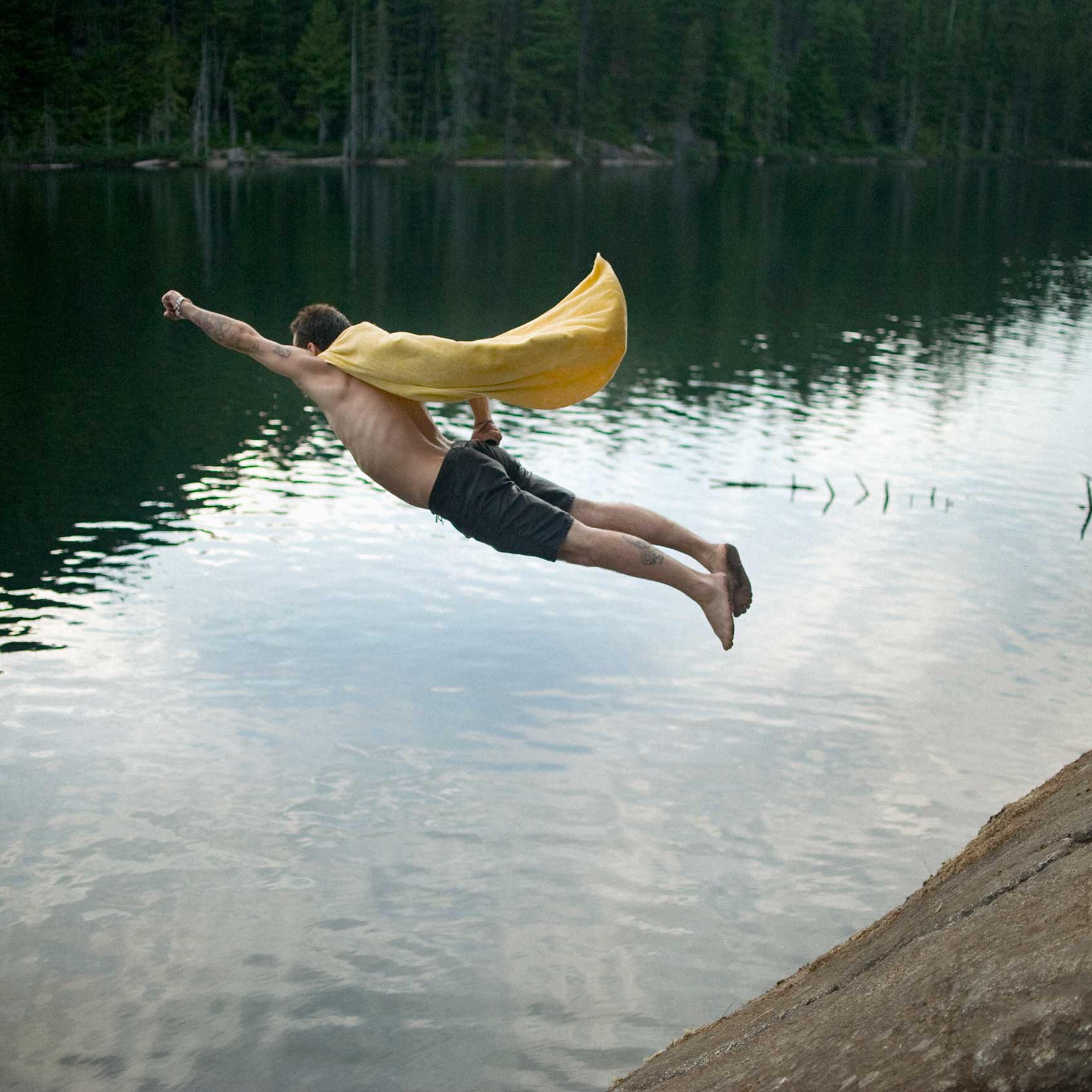 Full length of man dressed as superhero jumping in Brohm lake