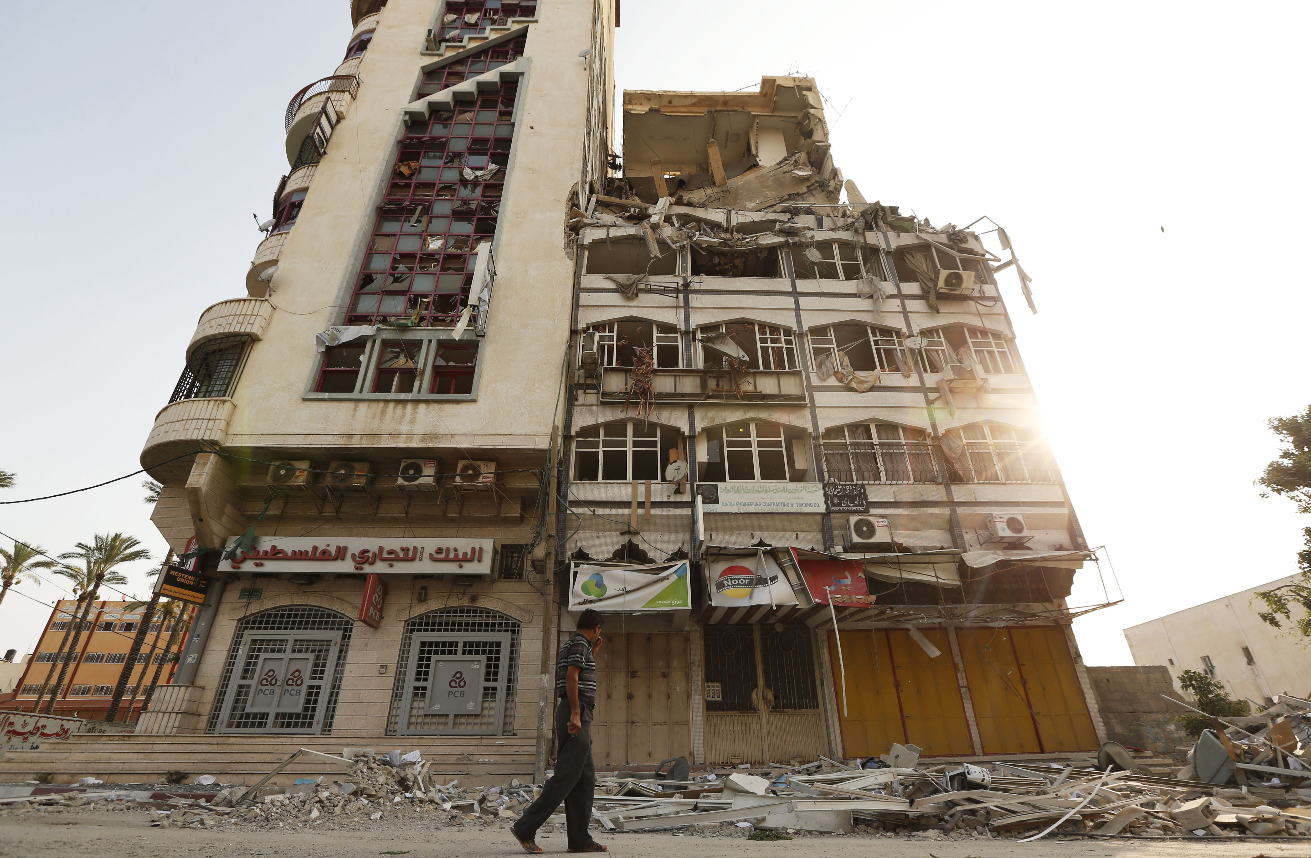 A Palestinian inspects the damage of the Al-Shalam (Peace) tower, destroyed by an overnight Israeli strike on July 22, 2014.