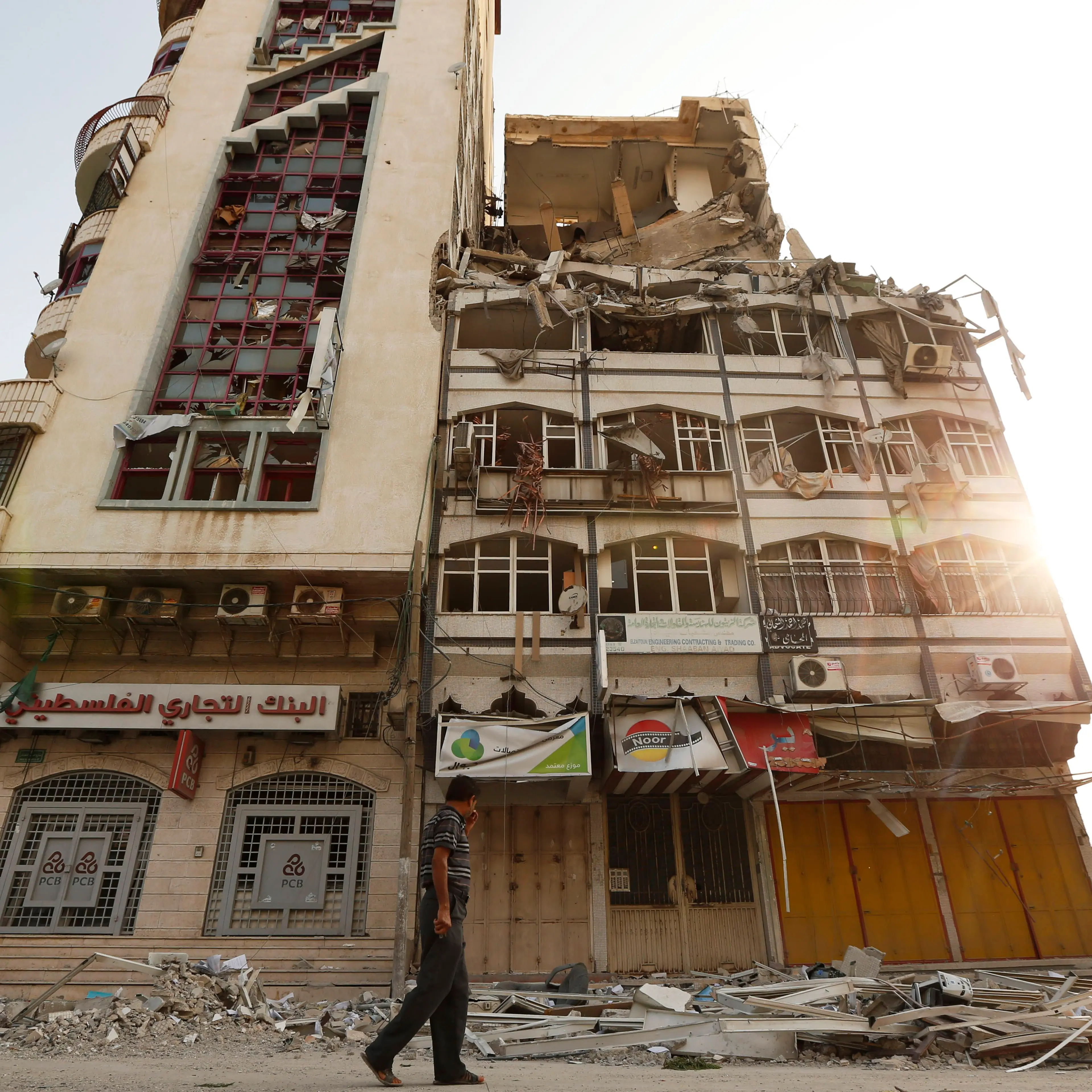A Palestinian inspects the damage of the Al-Shalam (Peace) tower, destroyed by an overnight Israeli strike on July 22, 2014.
