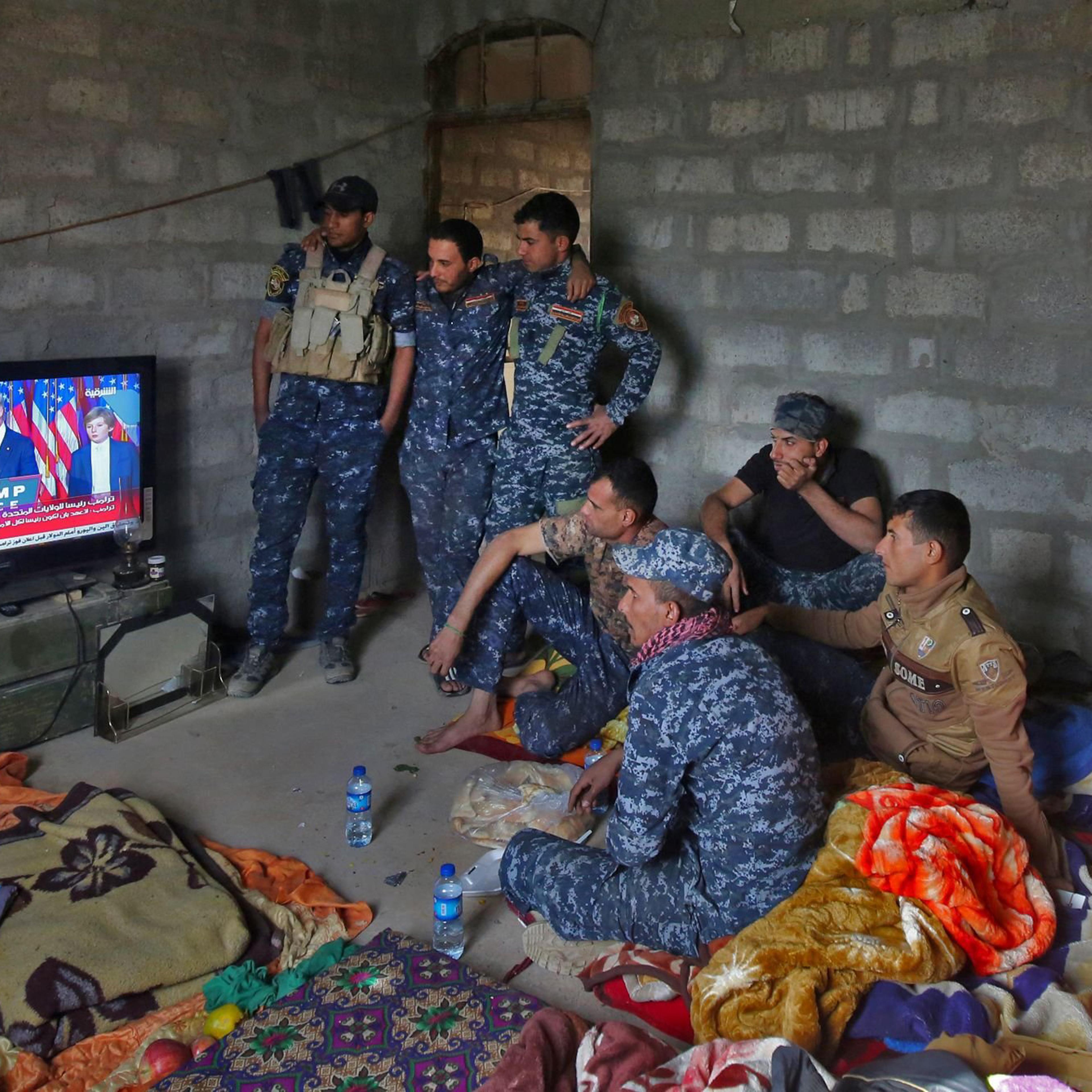 Members of the Iraqi forces watch President-elect Donald Trump give a speech after he won the U.S. presidential elections on a TV set while resting in the village of Arbid, on the southern outskirts of Mosul, on Nov. 9, 2016.