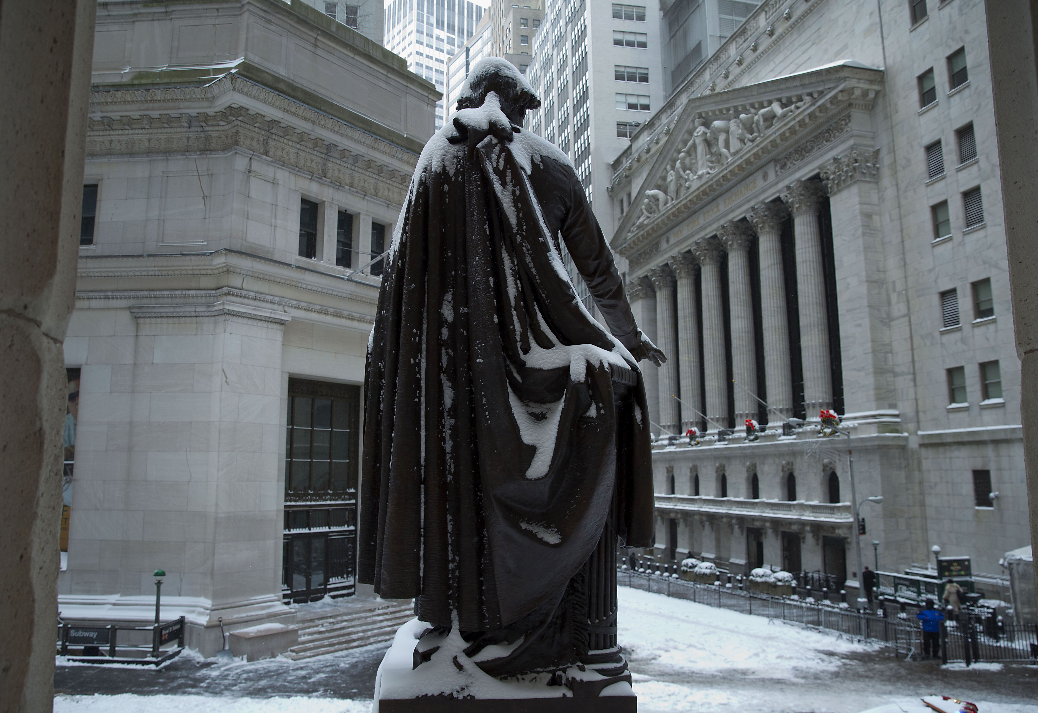 The George Washington statue stands covered in snow near the New York Stock Exchange (NYSE) in New York, U.S. Wind-driven snow whipped through New Yorks streets and piled up in Boston as a fast-moving storm brought near-blizzard conditions to parts of th