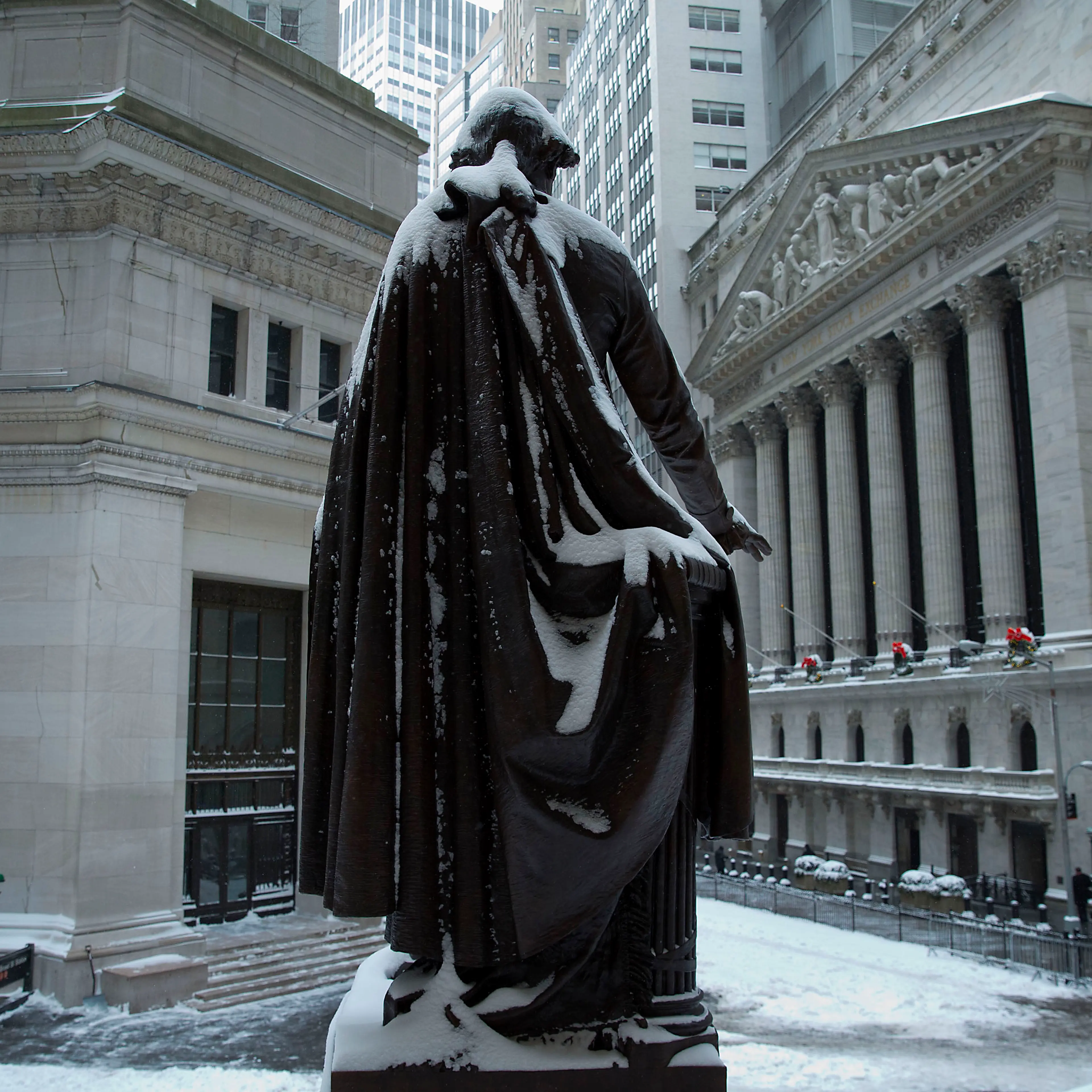 The George Washington statue stands covered in snow near the New York Stock Exchange (NYSE) in New York, U.S. Wind-driven snow whipped through New Yorks streets and piled up in Boston as a fast-moving storm brought near-blizzard conditions to parts of th