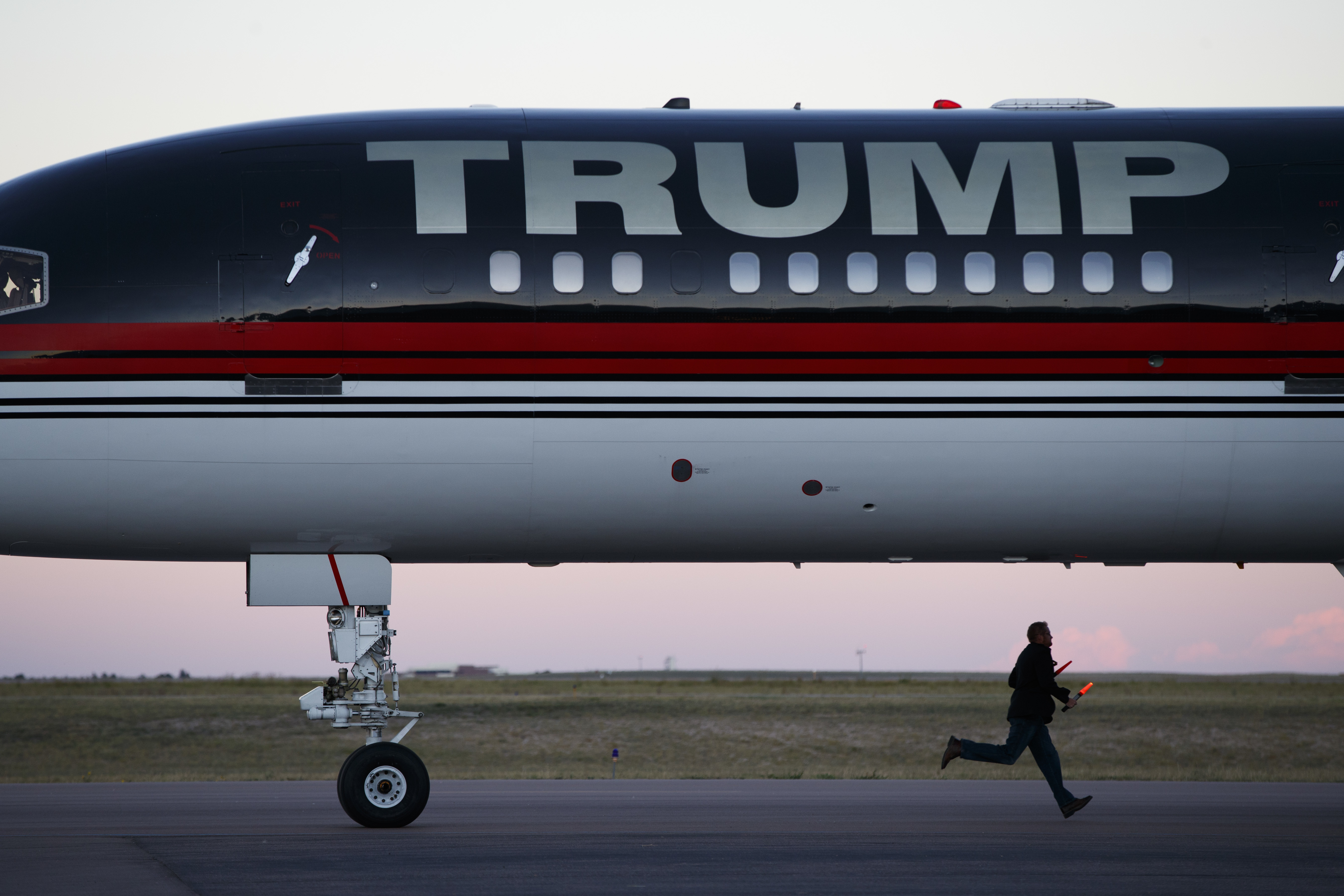 An airport worker races to prepare the stairs as the plane of Republican presidential candidate Donald Trump arrives for a campaign rally on Sept. 17, 2016, in Colorado Springs, Colo.
