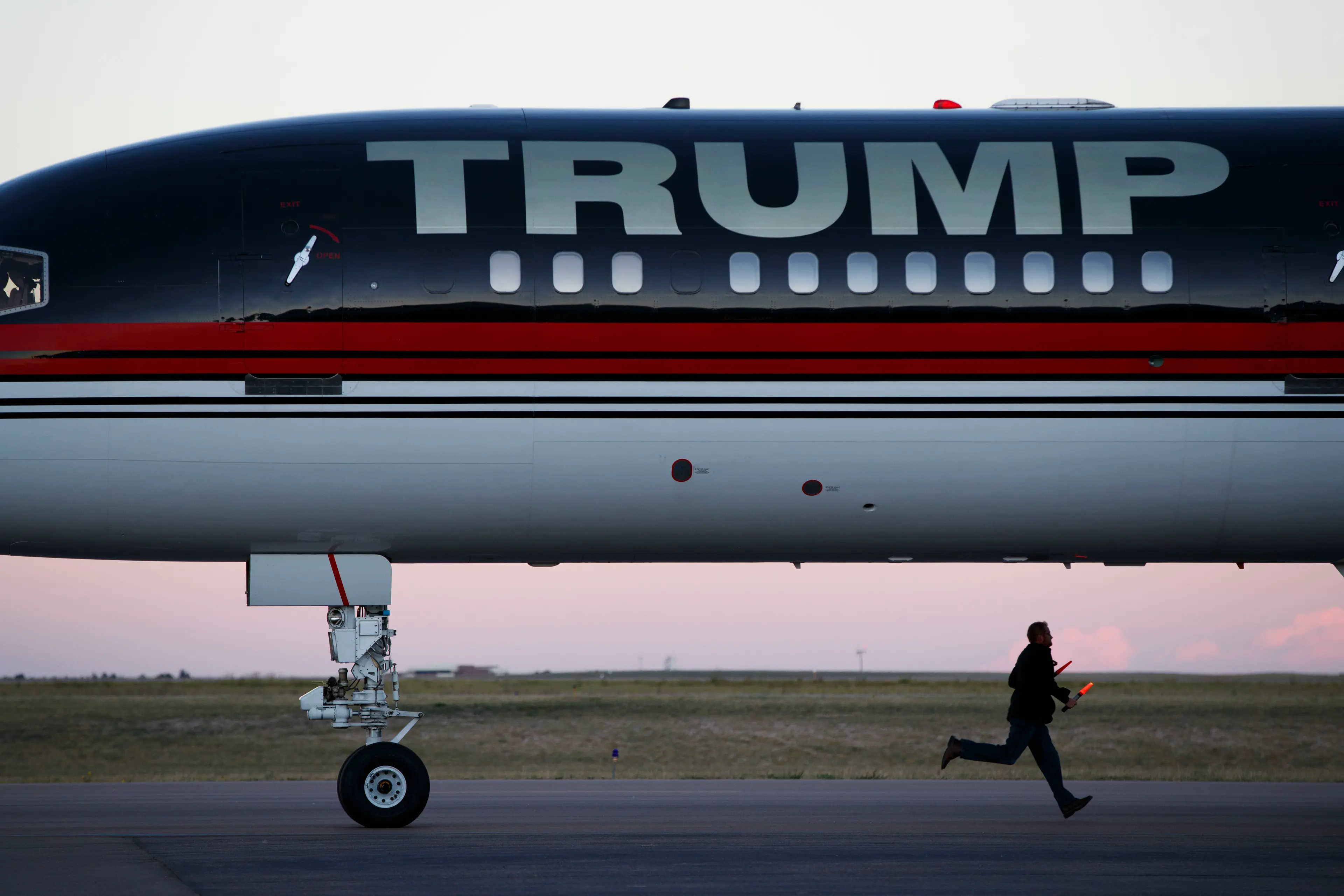 An airport worker races to prepare the stairs as the plane of Republican presidential candidate Donald Trump arrives for a campaign rally on Sept. 17, 2016, in Colorado Springs, Colo.